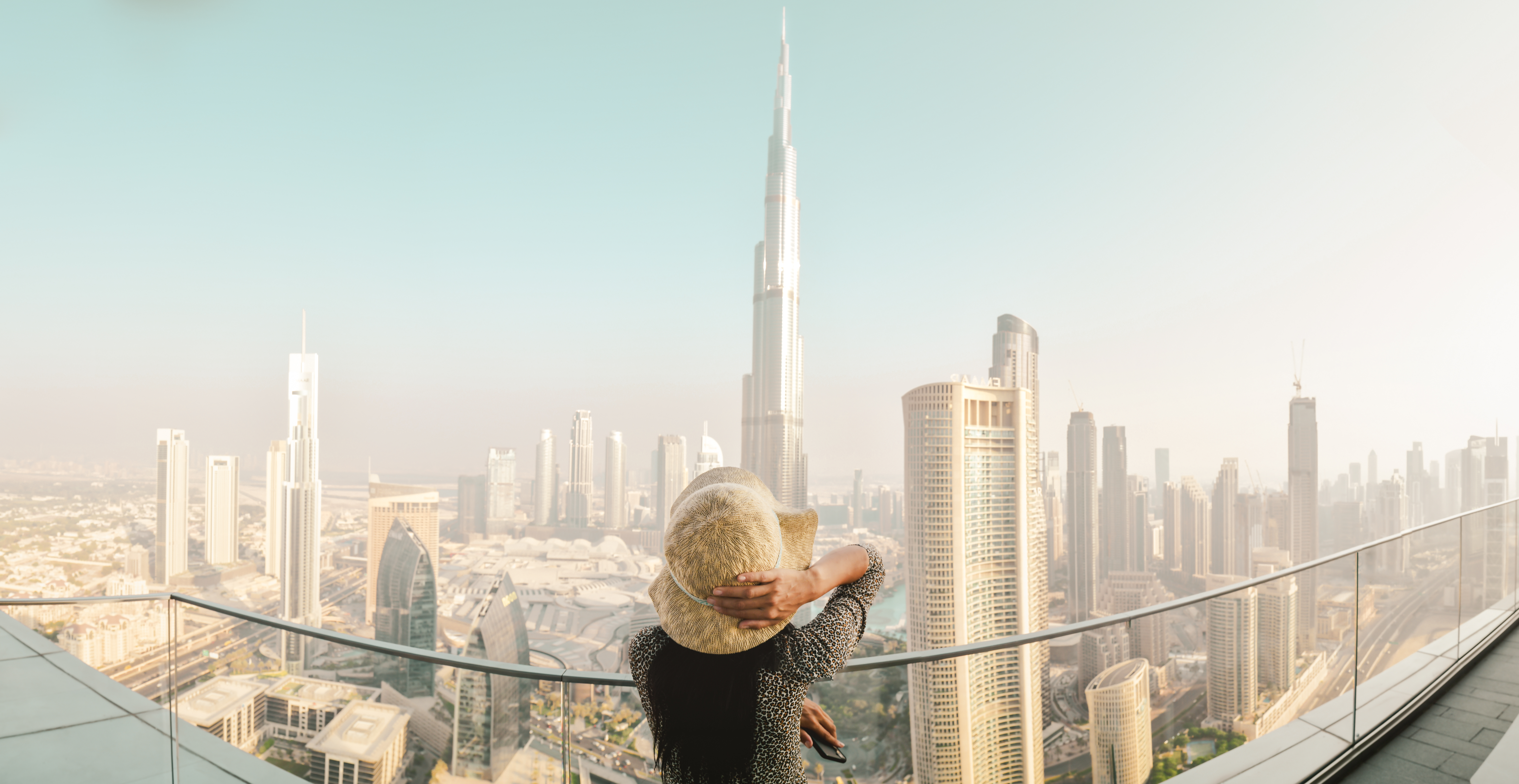 Dubai, UAE - 12th october, 2022: Burj Khalifa View from sky view downtown, lady by infinity pool looking at the tallest building in the world. Visit Dubai sky view hotel on holiday