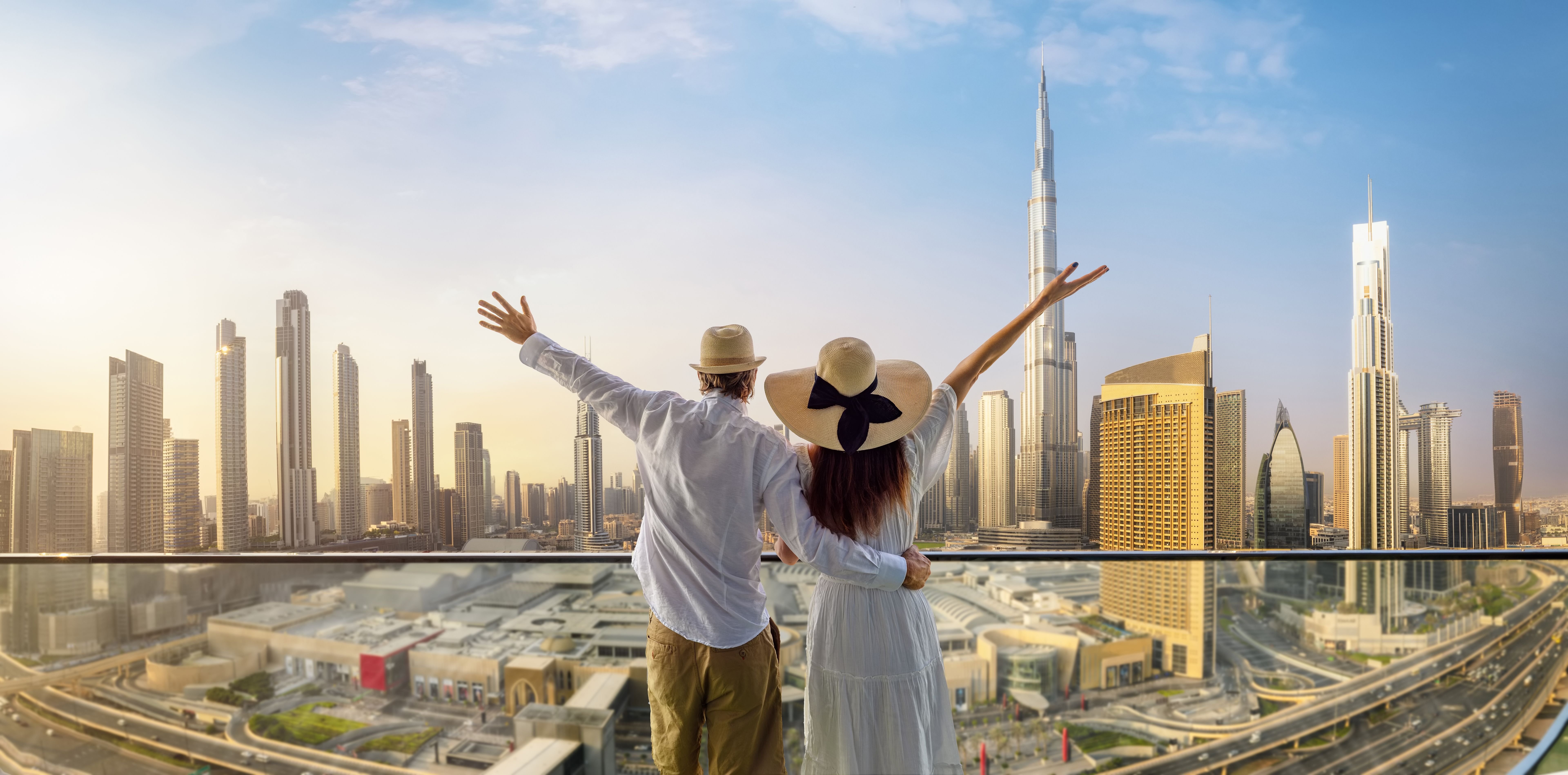 A tourist couple on vacation time enjoys the panoramic view of the Dubai skyline