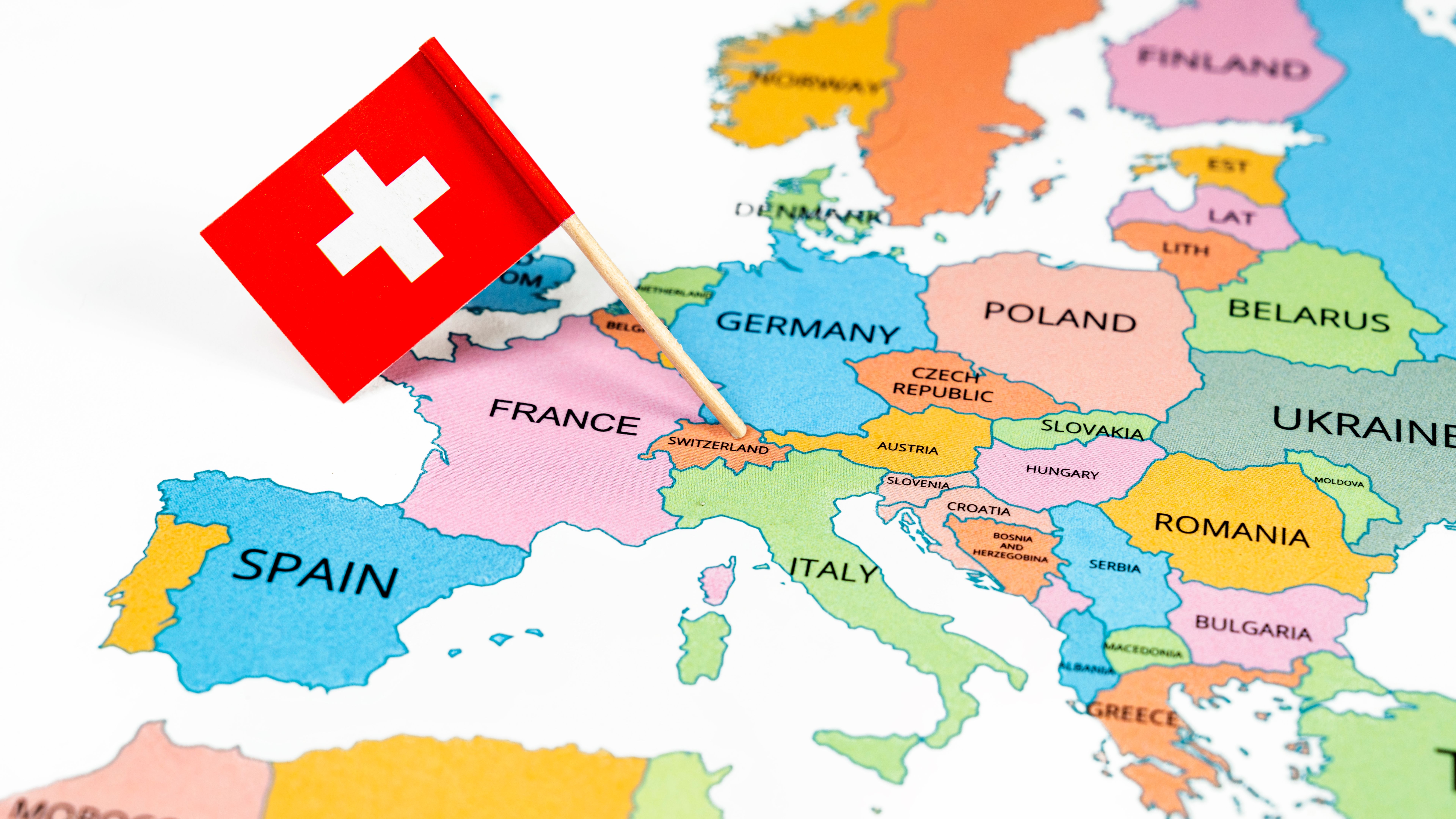 A map of Switzerland with the national flag of Switzerland on it. The flag is a white cross in the center of a square red field