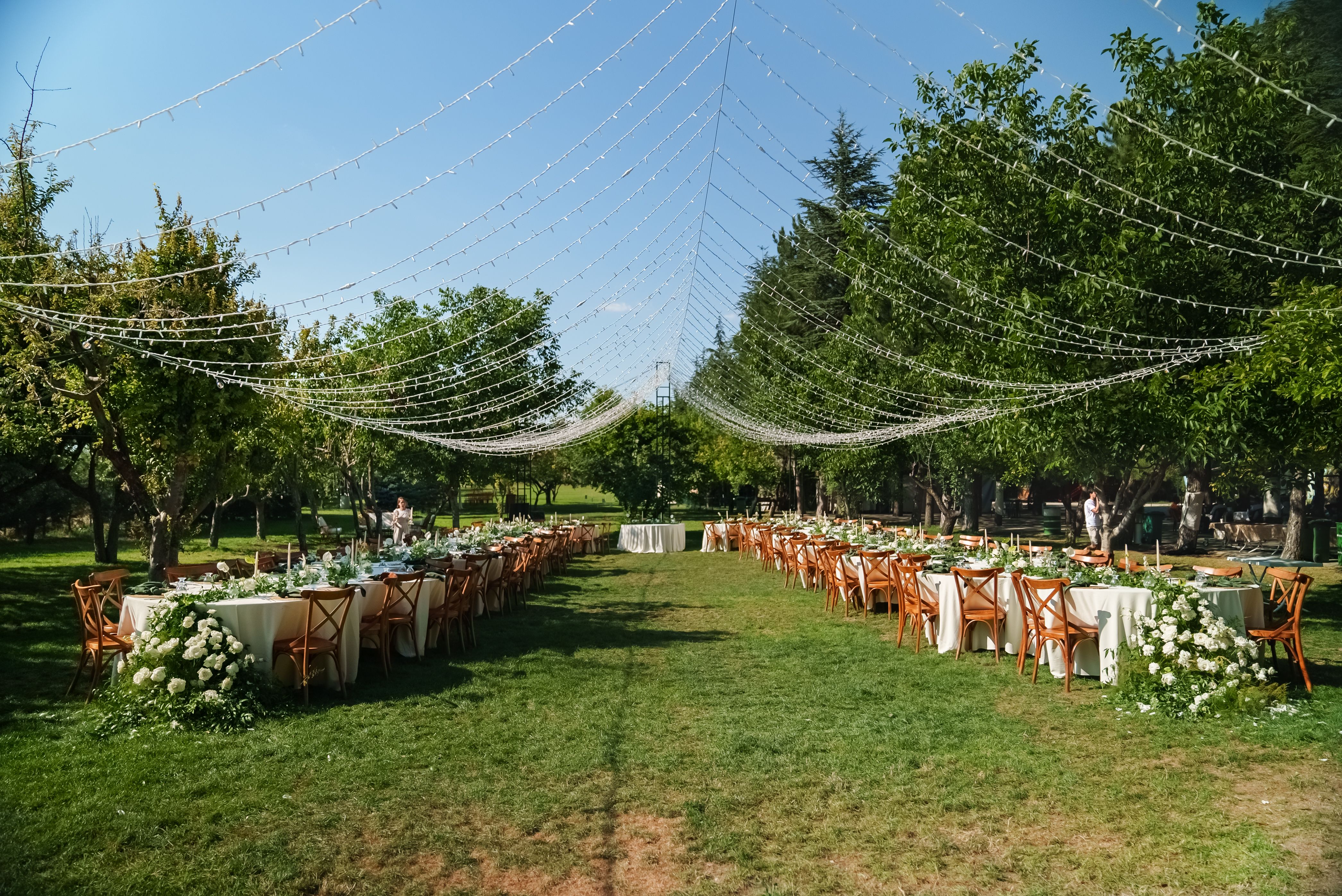 Wide shot of decorated dining tables at an outdoor rustic wedding Wide shot of decorated dining tables at an outdoor rustic wedding