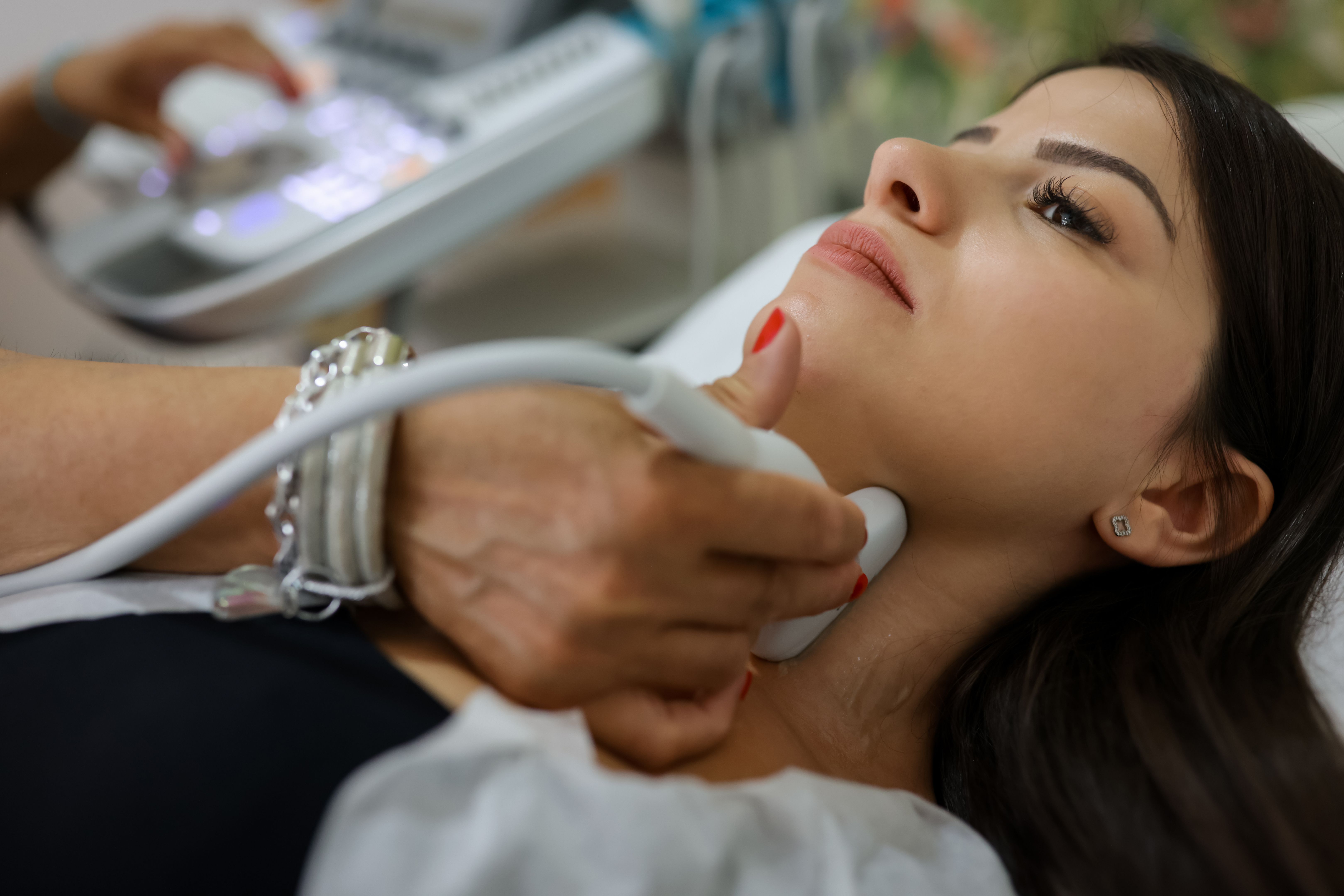 Close up shot of young woman getting her neck examined by doctor using ultrasound scanner at modern clinic s Close up shot of young woman getting her neck examined by doctor using ultrasound scanner at modern clinic s