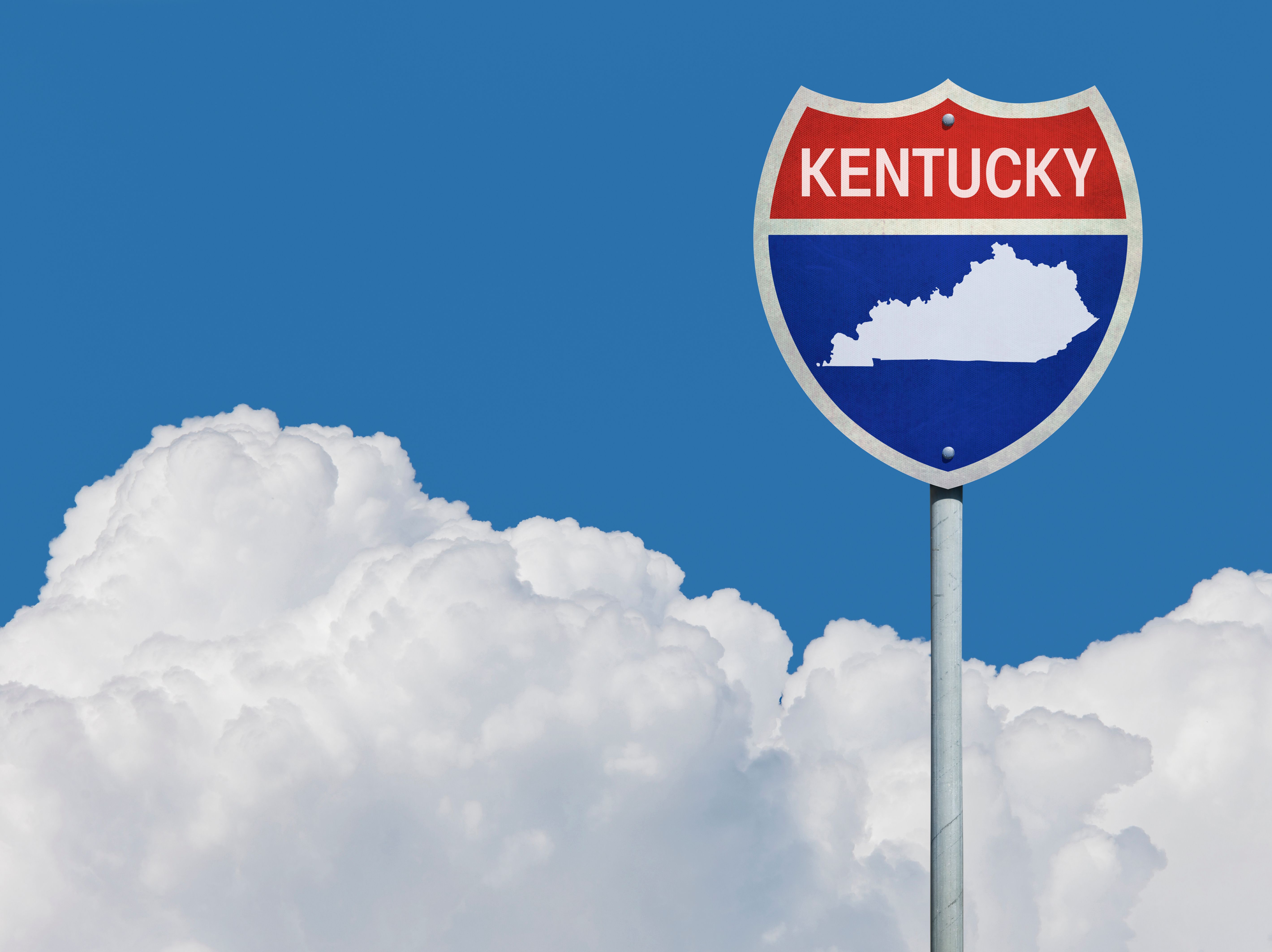 Highway sign for Interstate road in Kentucky with map in front of clouds