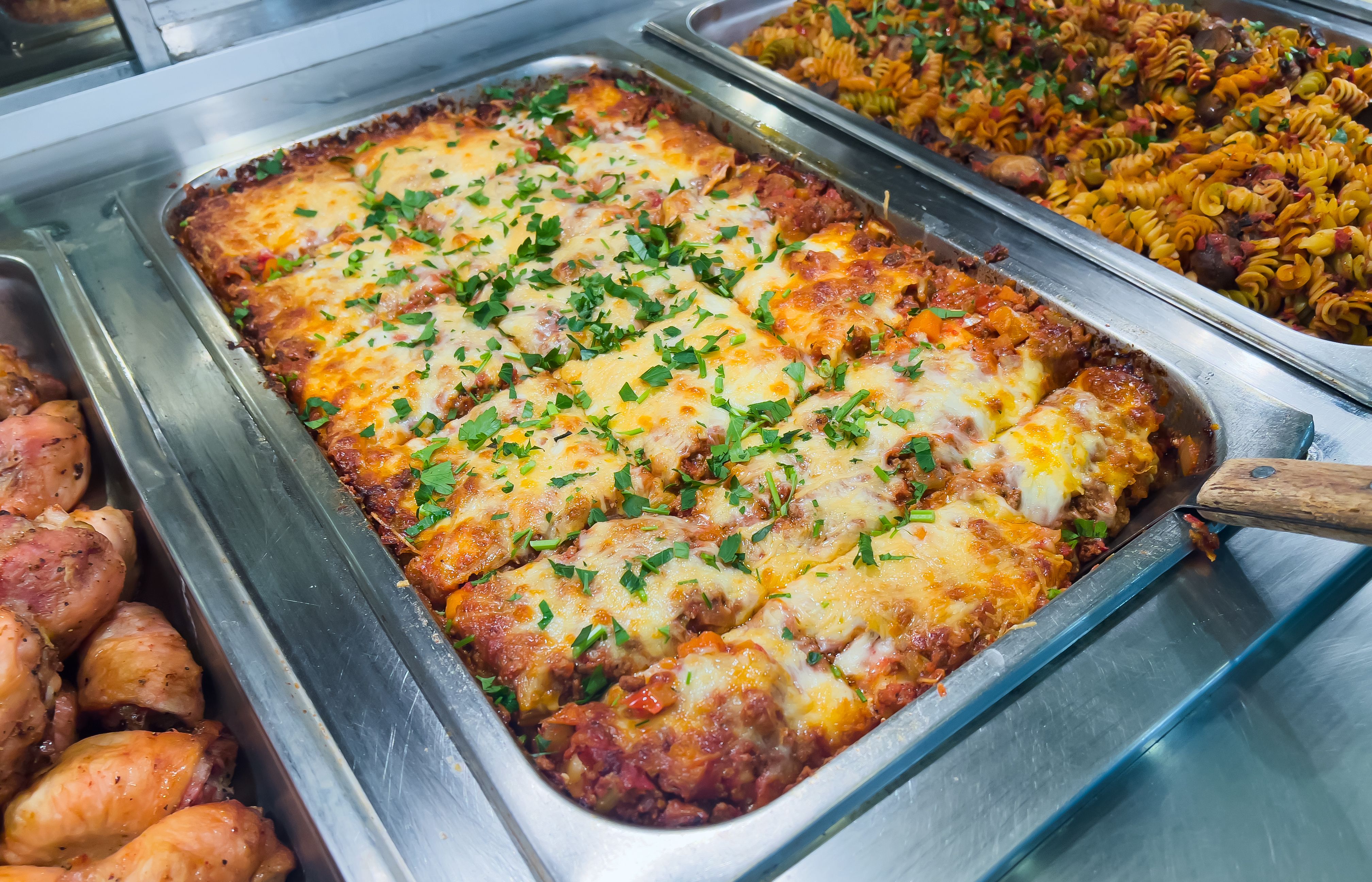 Tray of homemade italian lasagna at a restaurant of or supermarket self serve buffet
