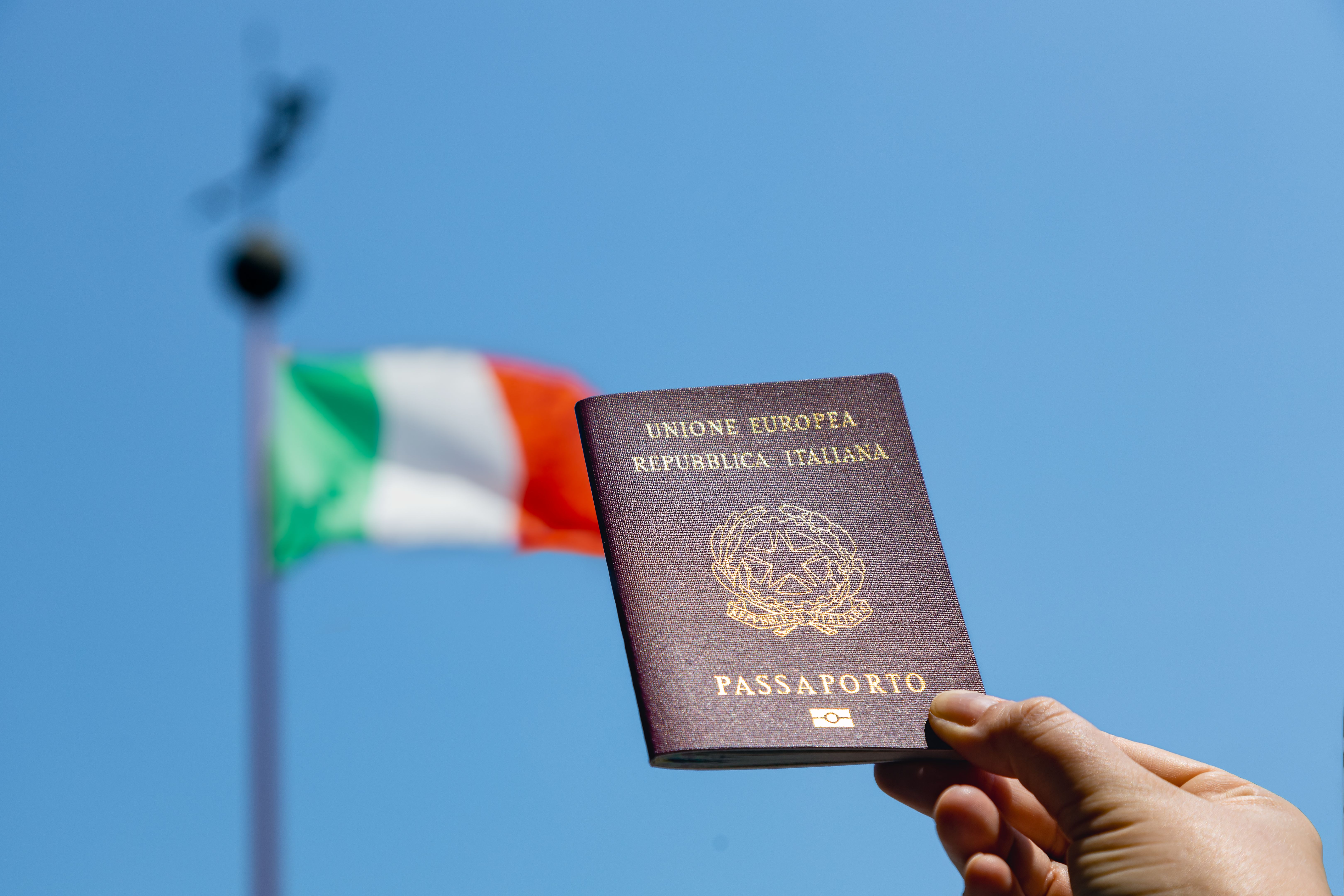 Passaporto italiano con bandiera italiana sullo sfondo