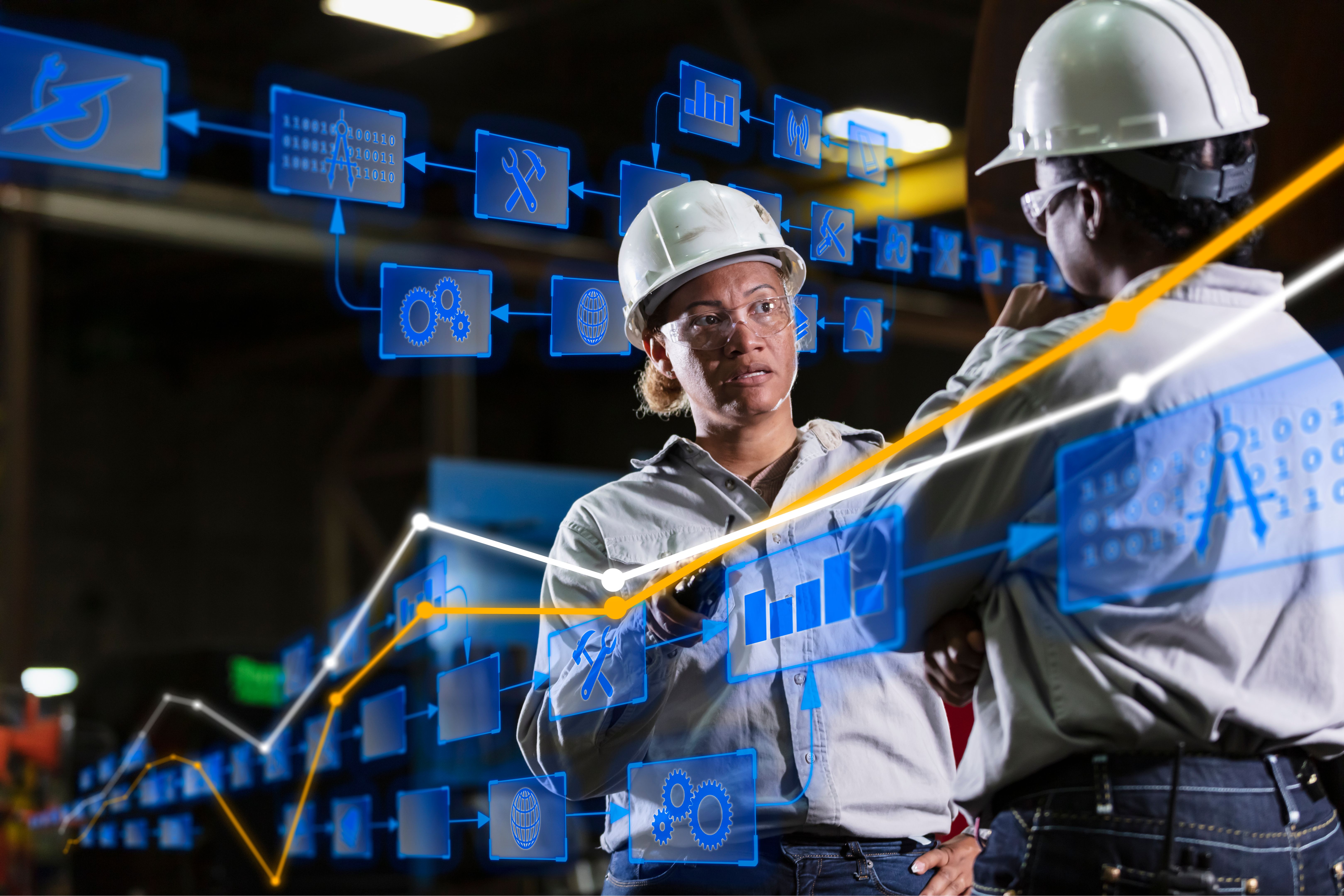 Two multiracial women engineers in warehouse conversing