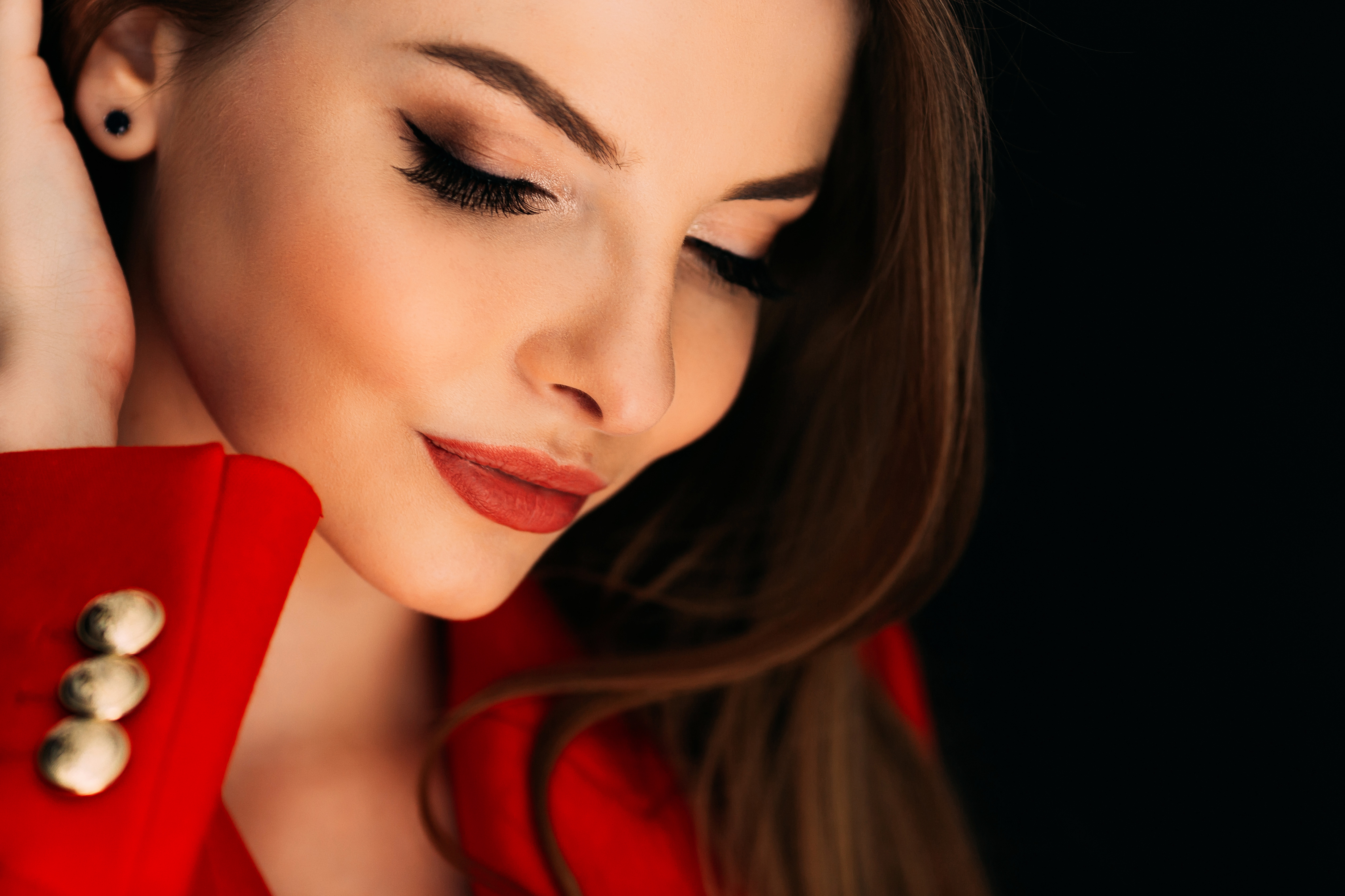 Closeup of a beautiful model makeup looking down on dark backgro