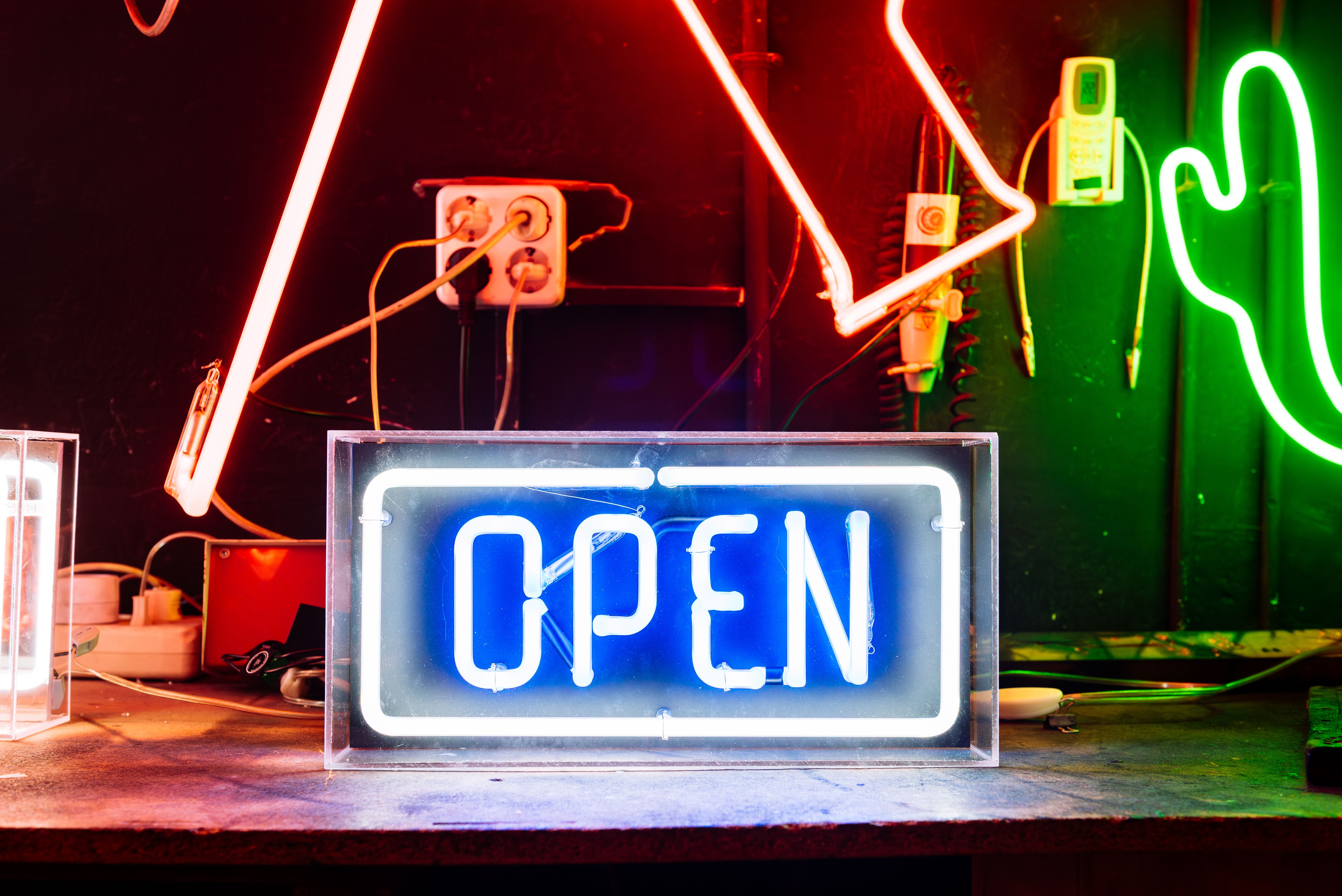Blue Neon Open Sign In A Workshop With Other Neon Signs