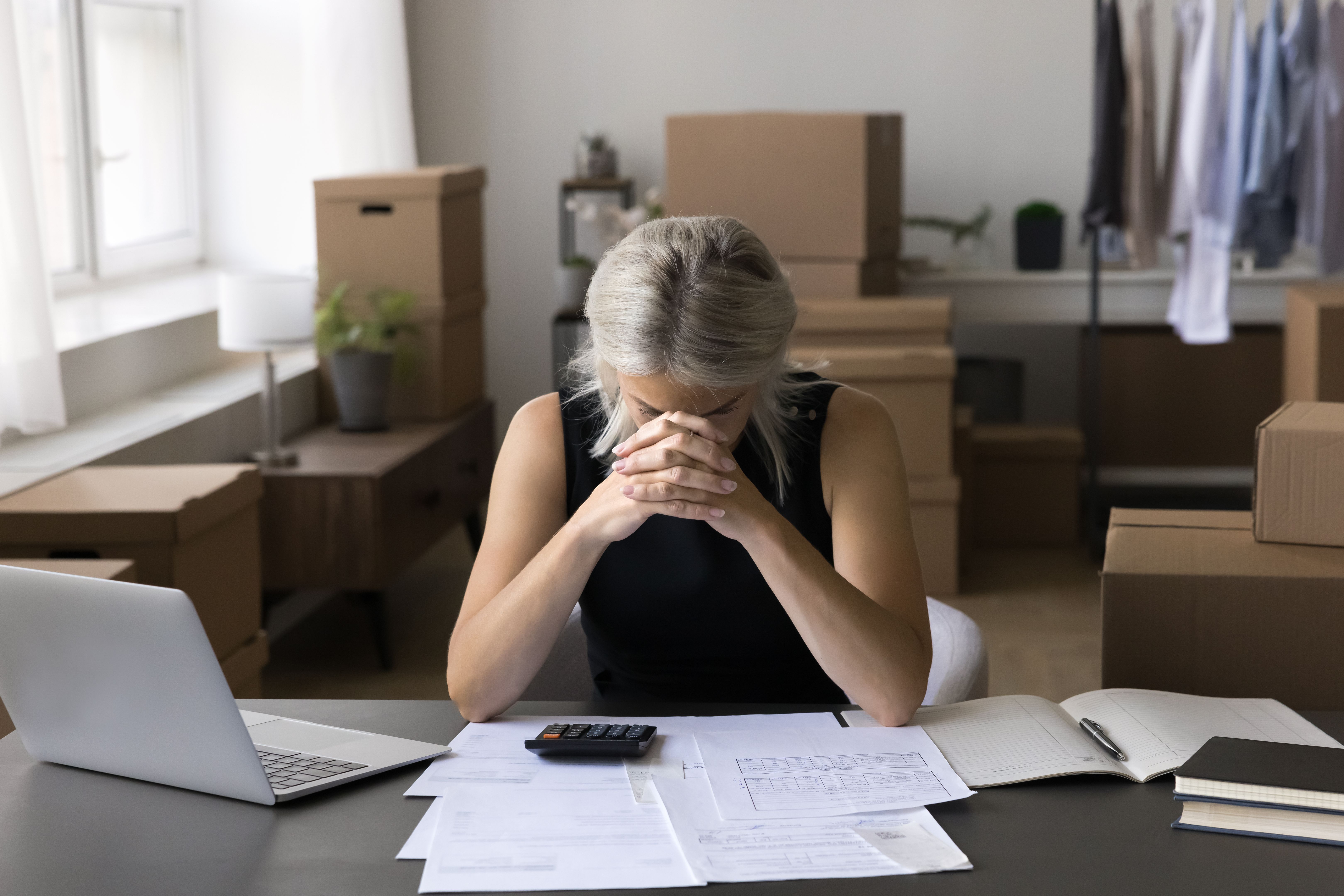 Stressed businesswoman paying heap of unpaid bills Stressed businesswoman paying heap of unpaid bills