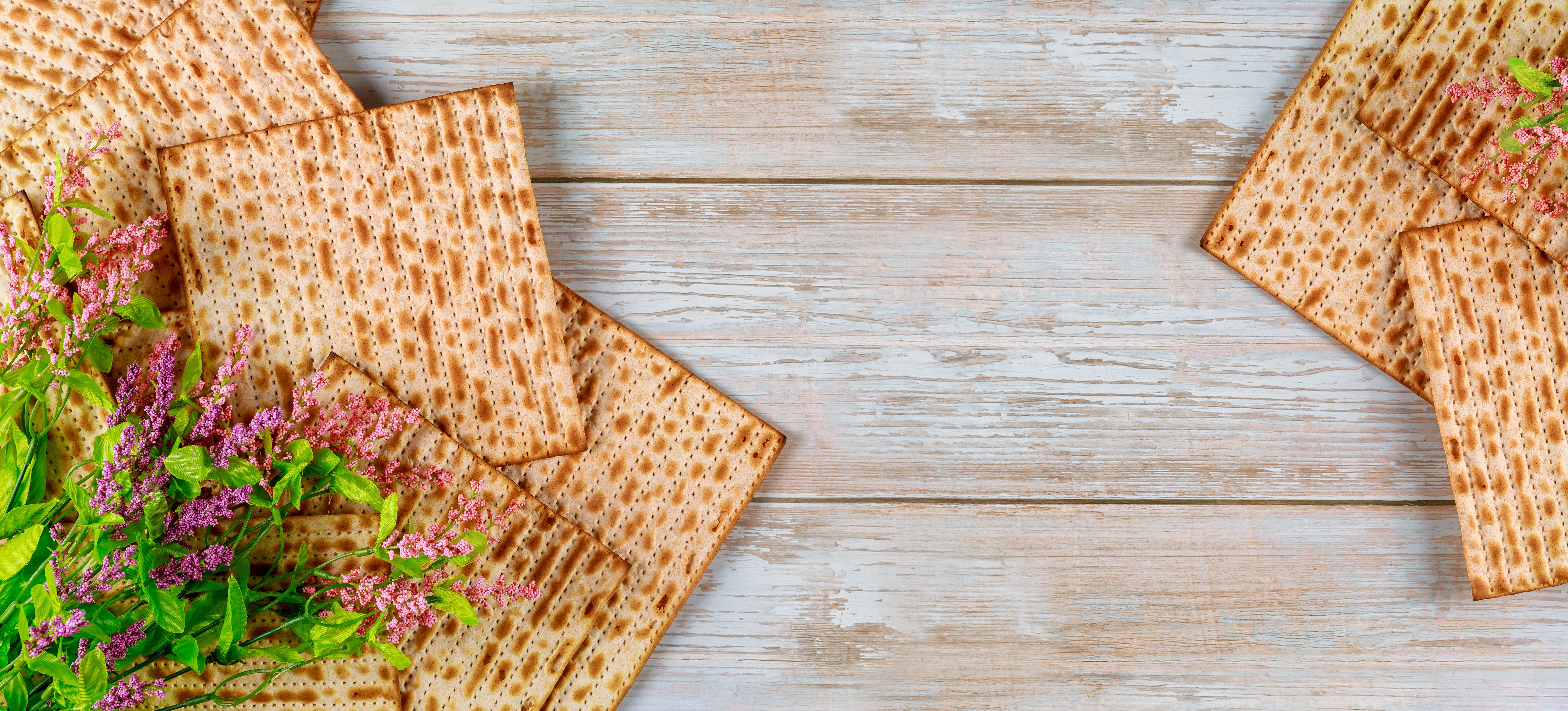 Background of matzah bread with flowers. Jewish Passover holiday concept.