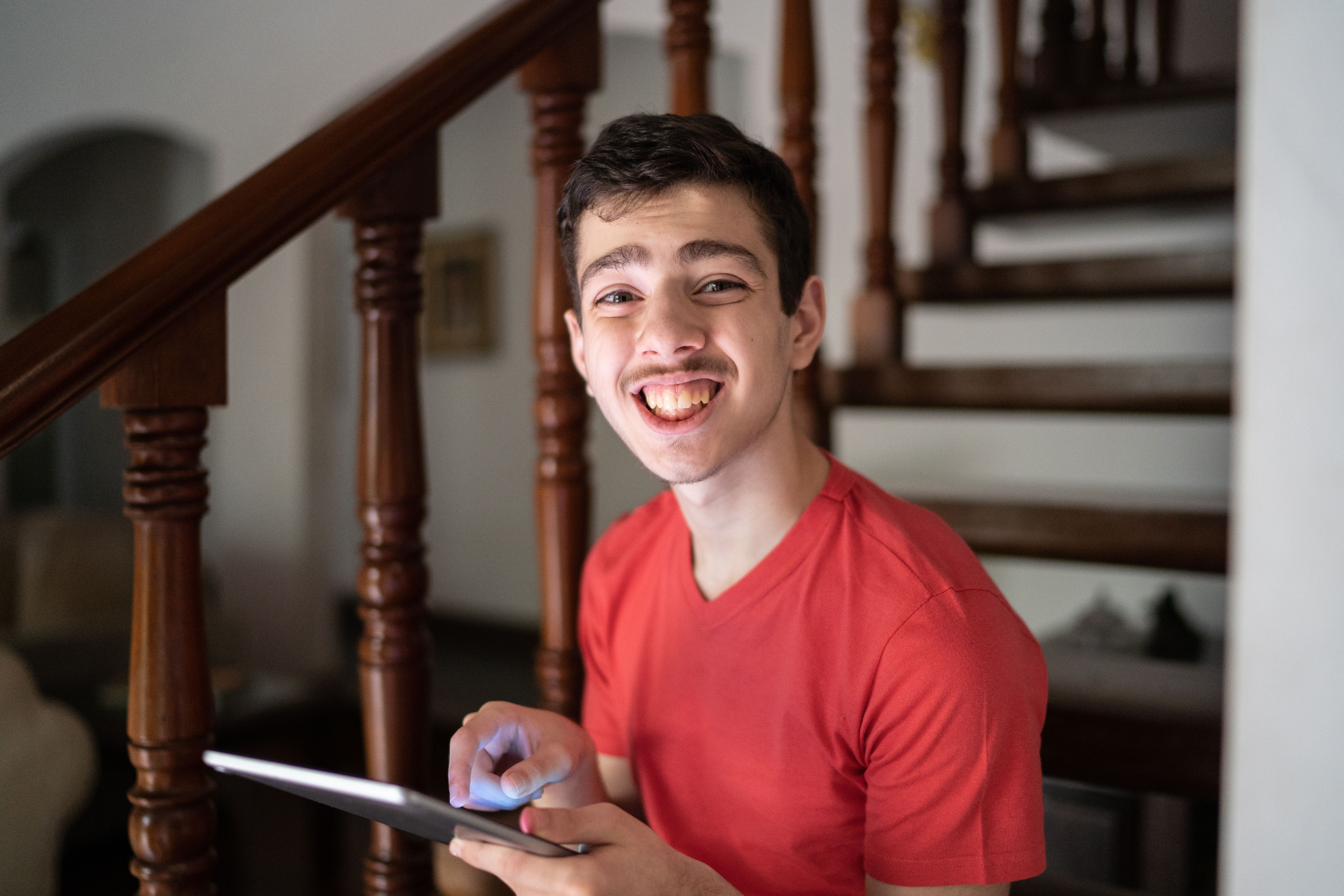 Portrait of a teenager boy holding a digital tablet at home