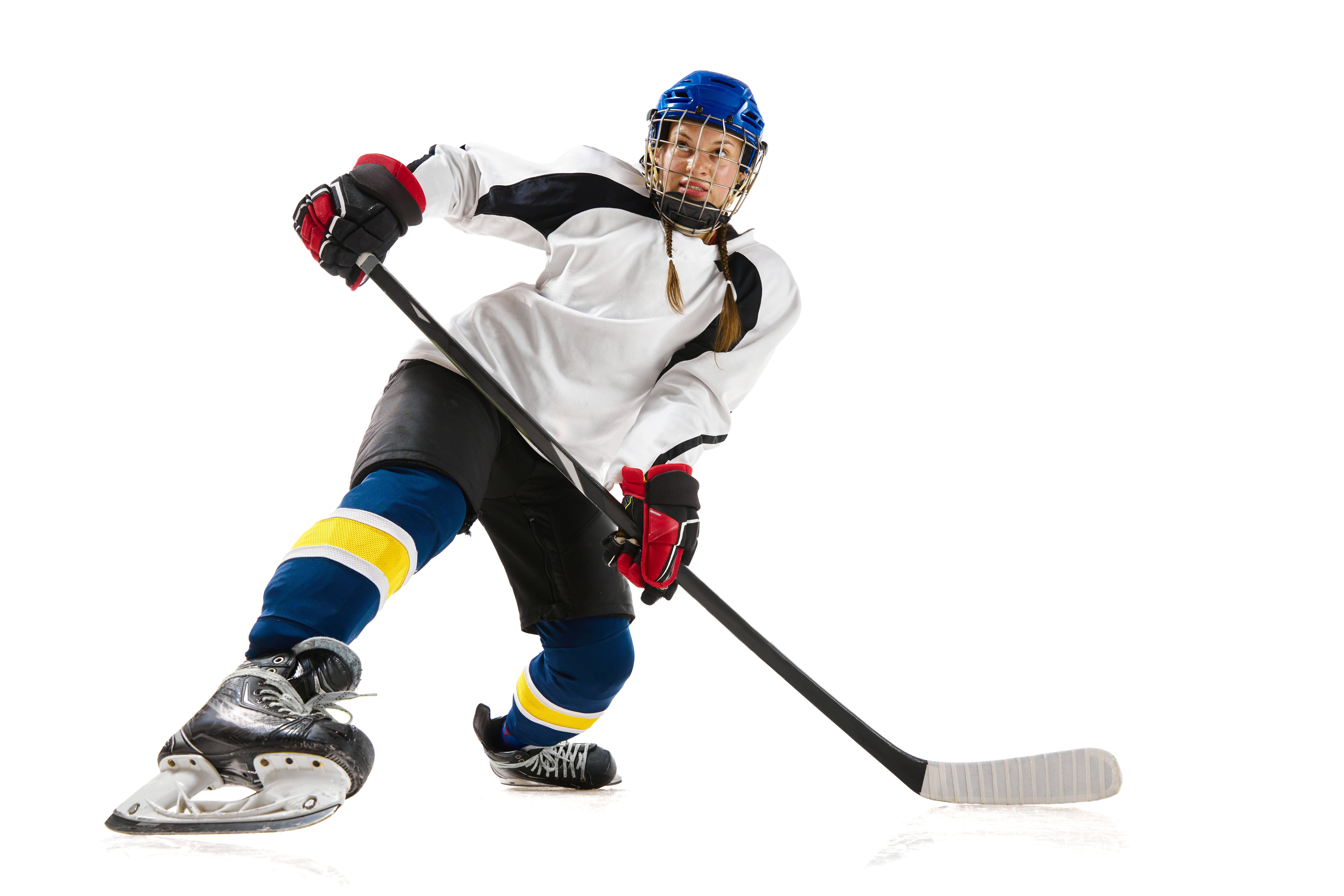 Young girl, hockey playing in helmet, uniform, with stick training, playing isolated over white background