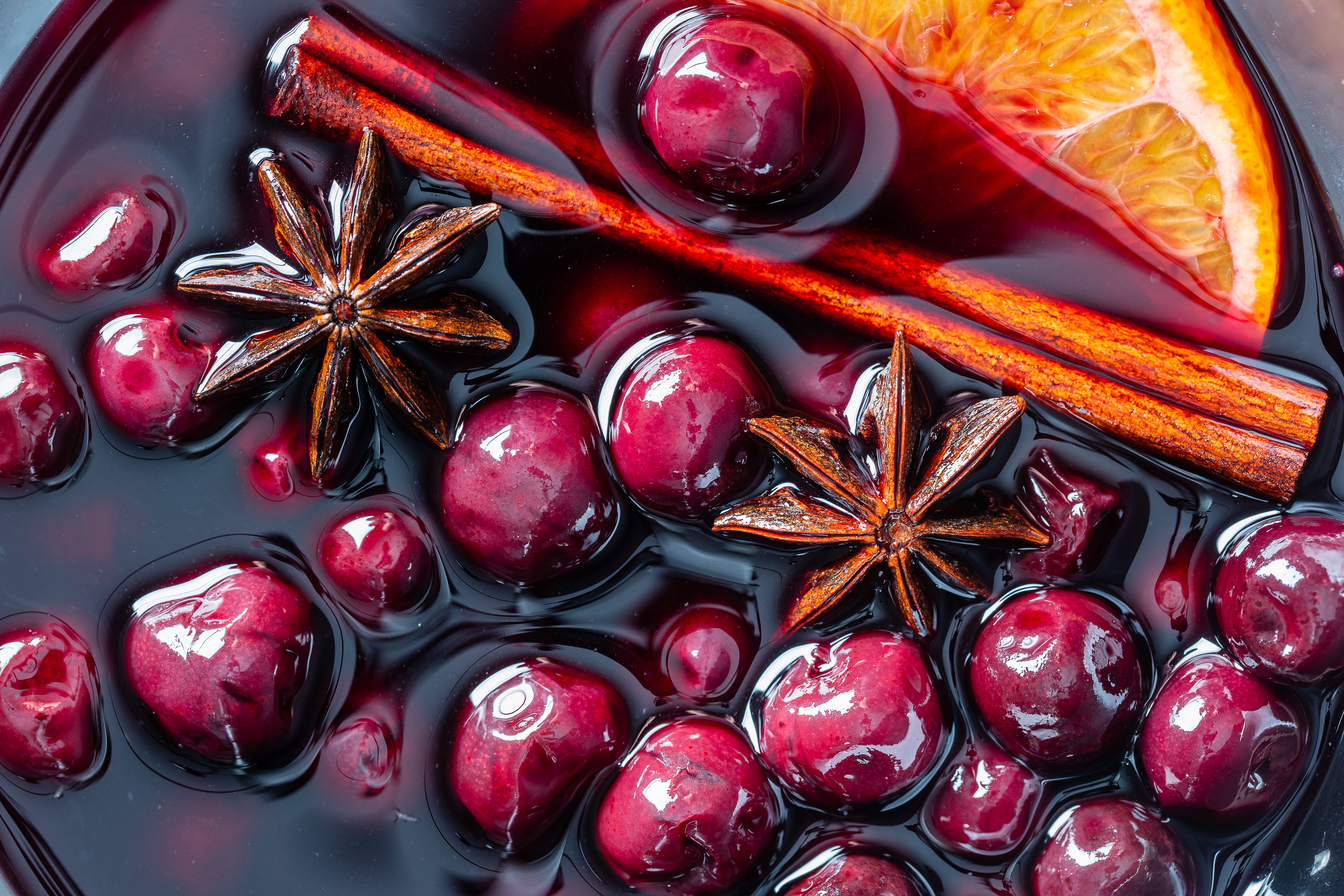 Mulled red cherry wine or punch with slice of orange and anise star and cinnamon. Christmas beverage.