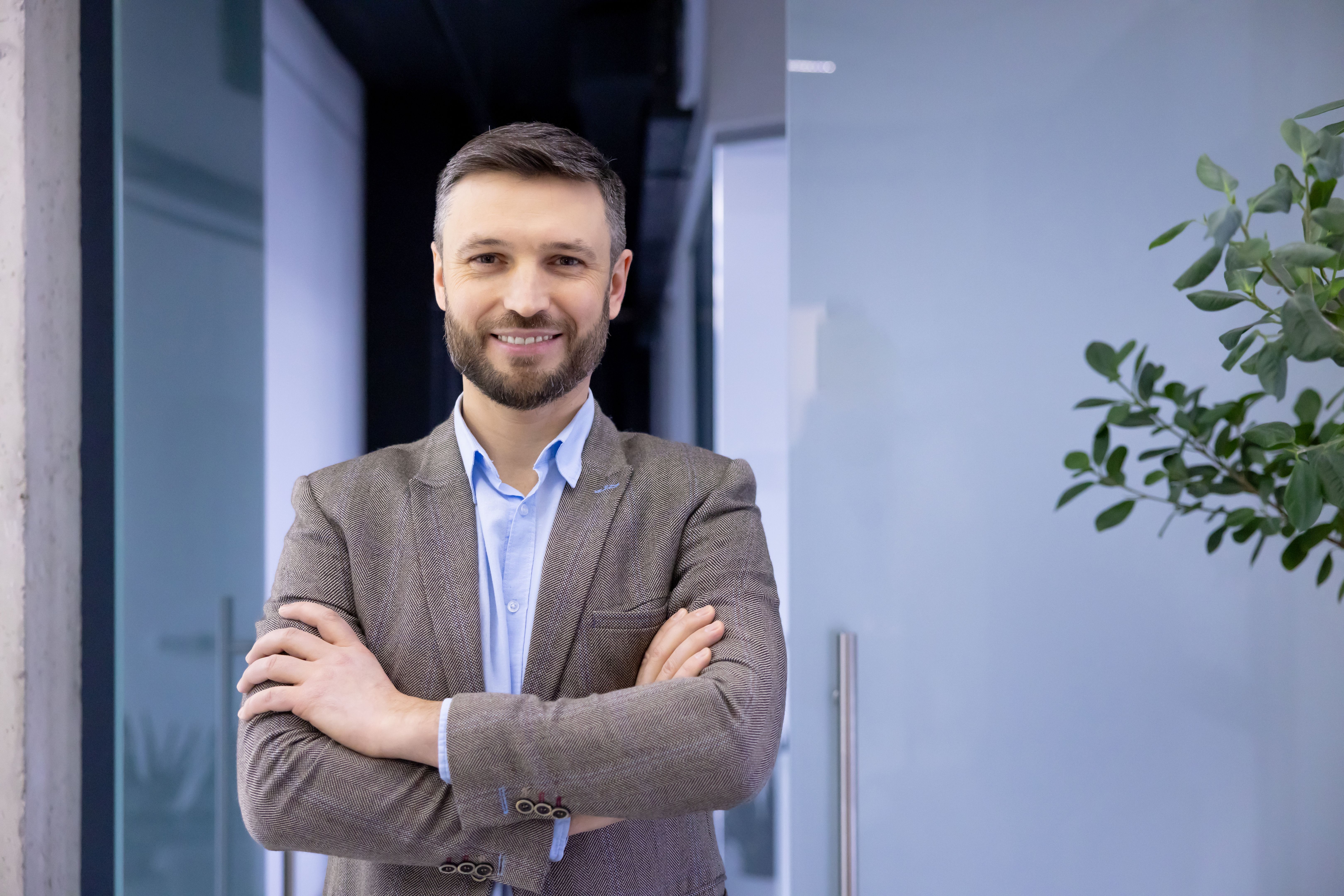 Portrait of mature successful businessman in business suit inside office, experienced satisfied man looking at camera with crossed arms, senior financier accountant