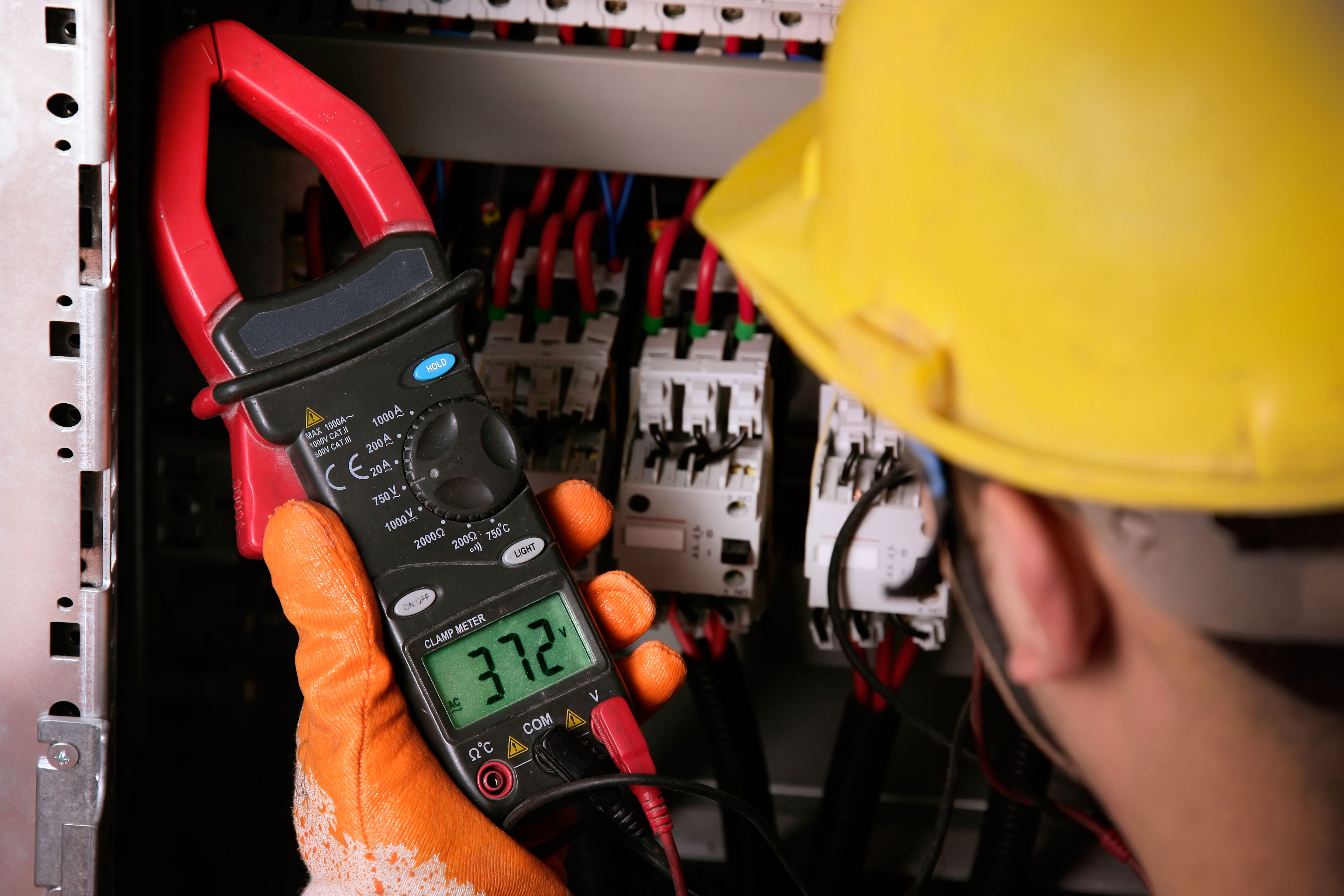 Electrician working on electric panel Electrician working on electric panel