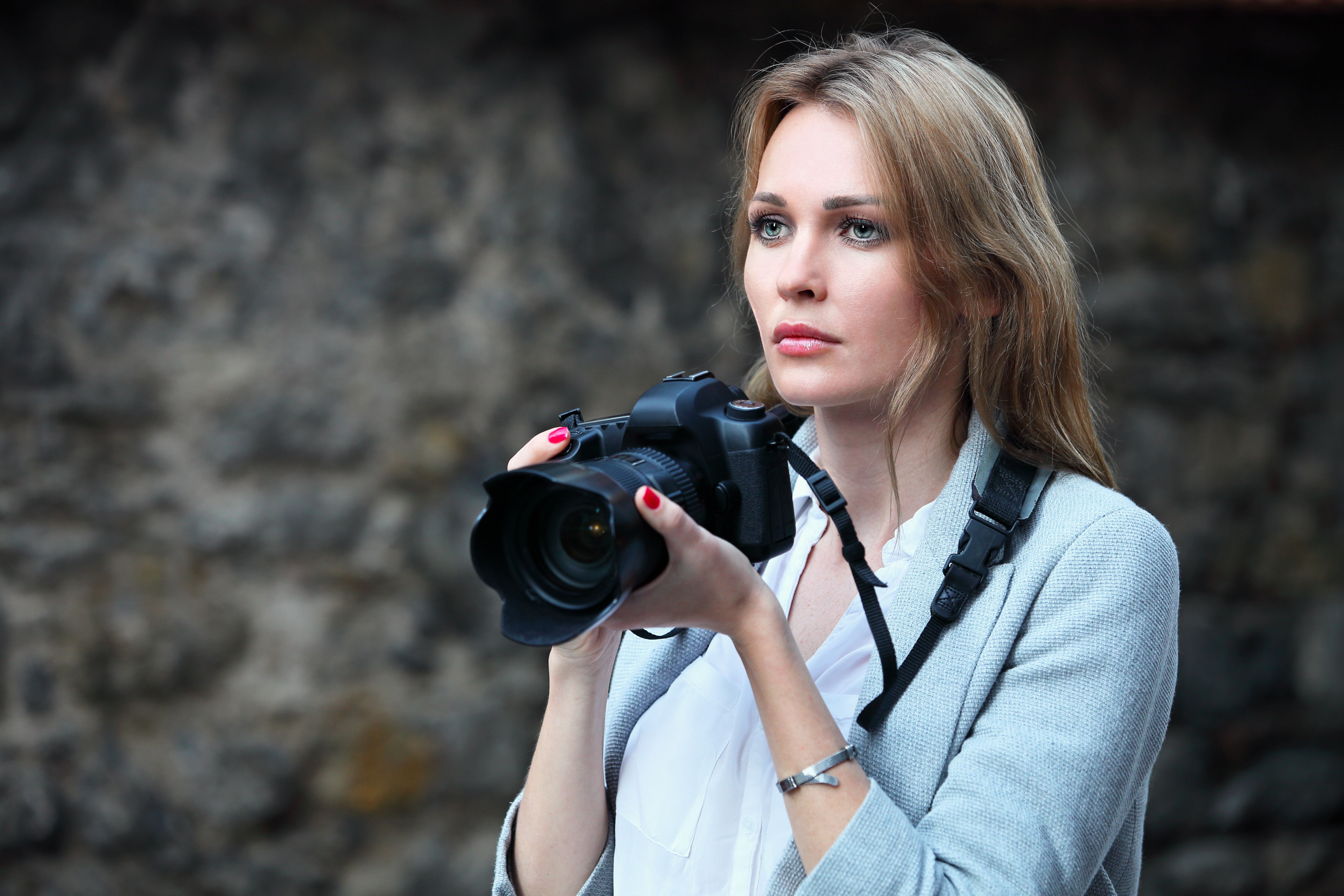 Beautiful woman photographer taking photos in the city