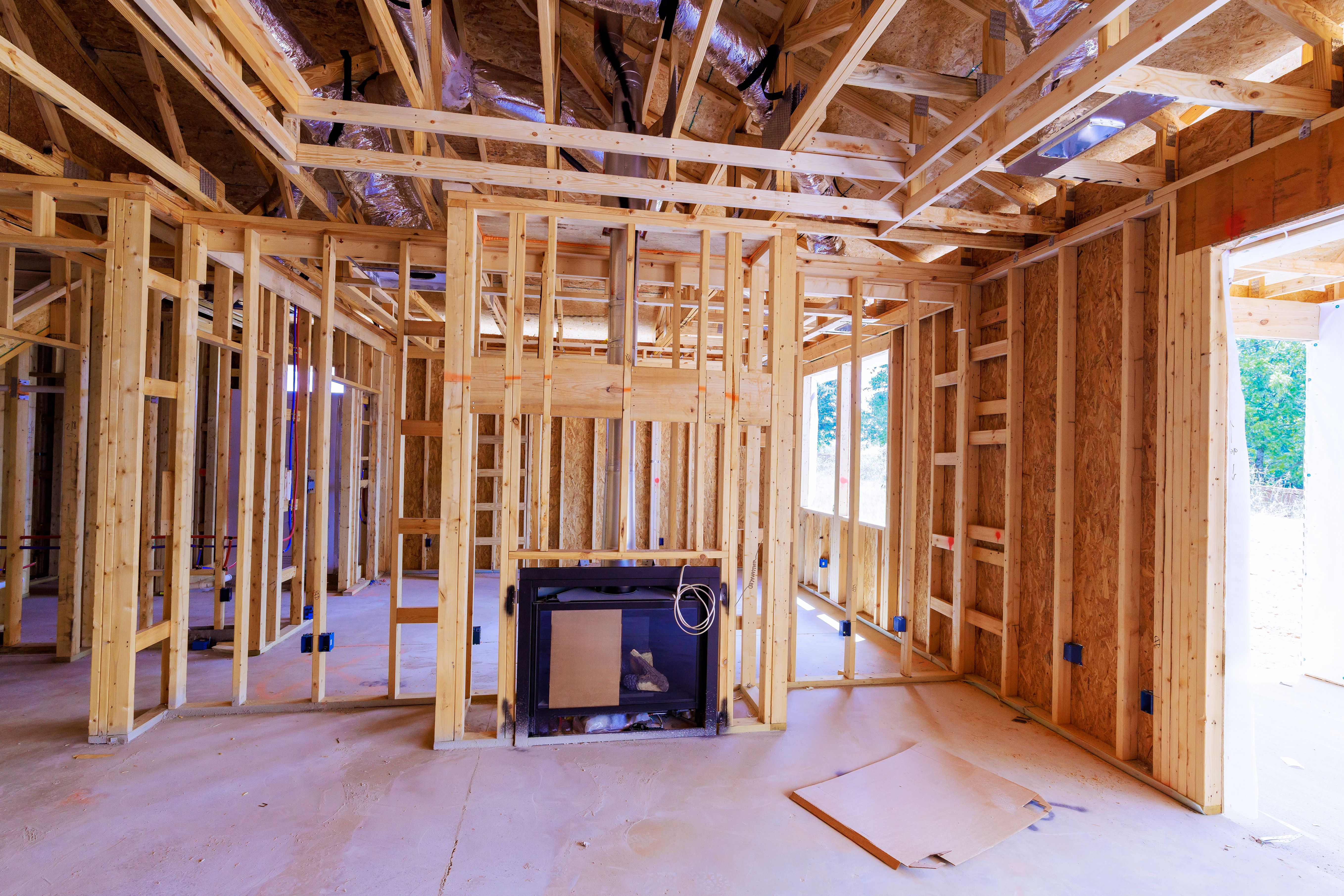 Construction of new house interior with framed walls fireplace being installed