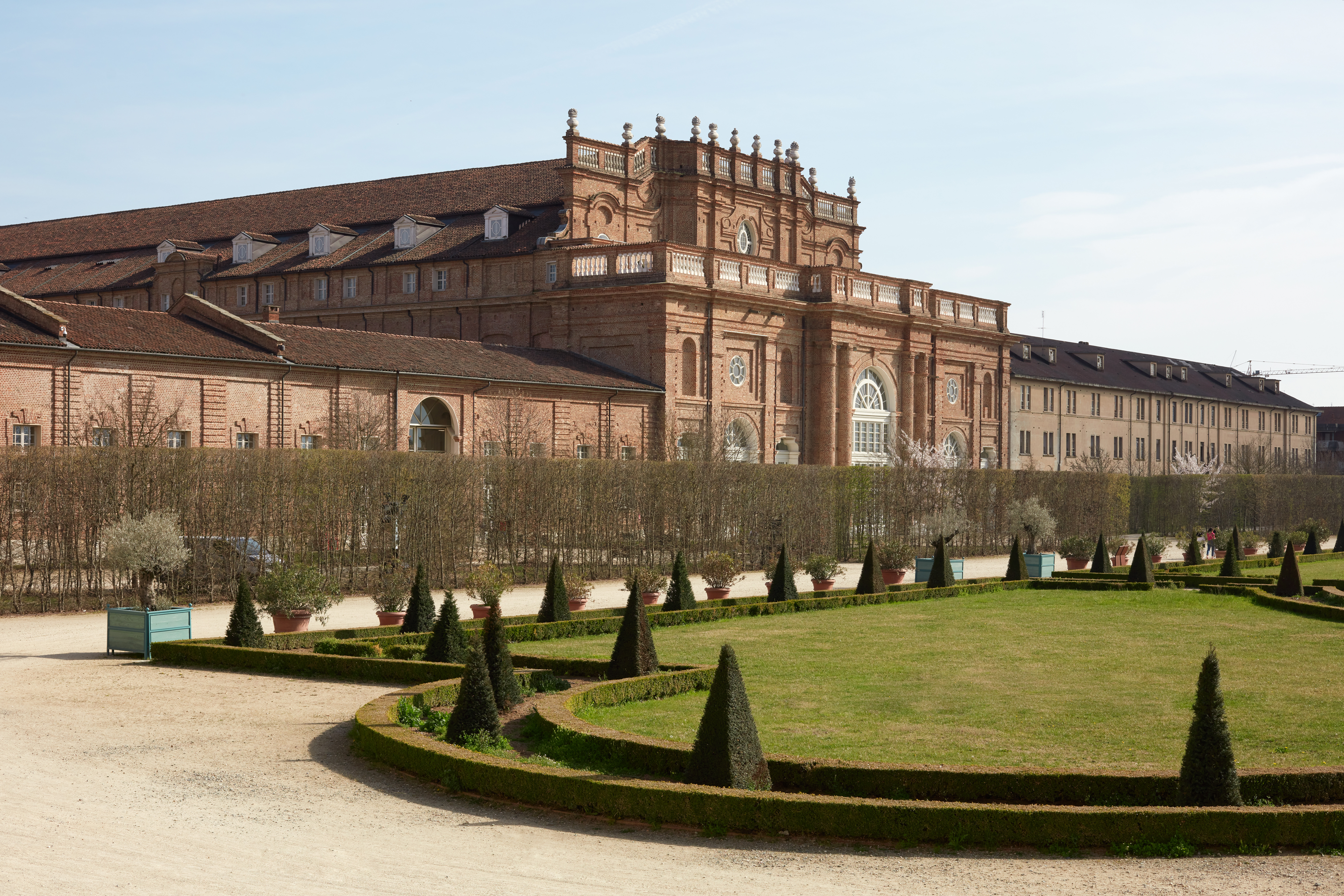 Reggia di Venaria castle architecture and park with pyramidal hedges in spring sunlight Reggia di Venaria castle architecture and park with pyramidal hedges in spring sunlight