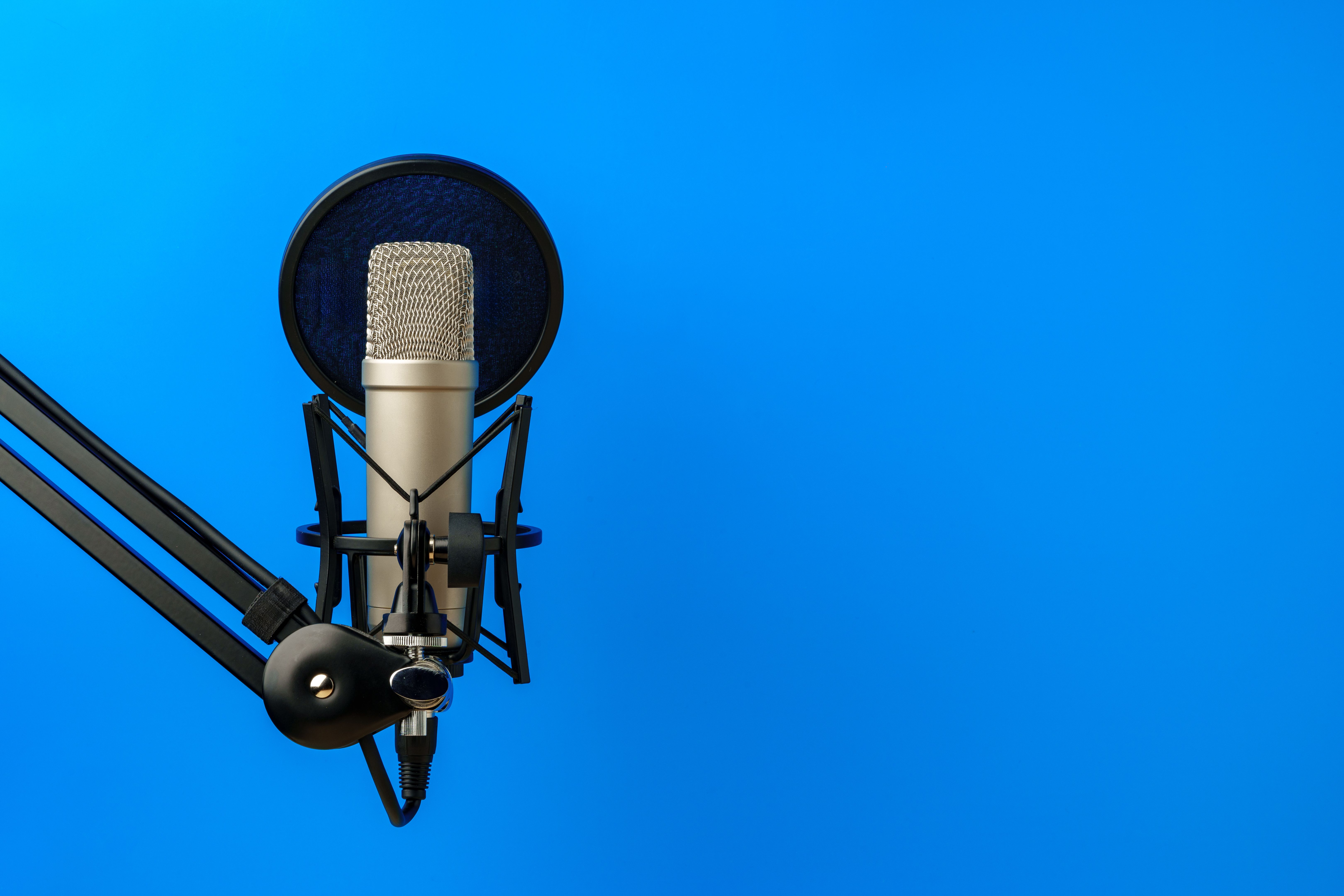 Soporte de micrófono profesional sobre fondo de estudio azul