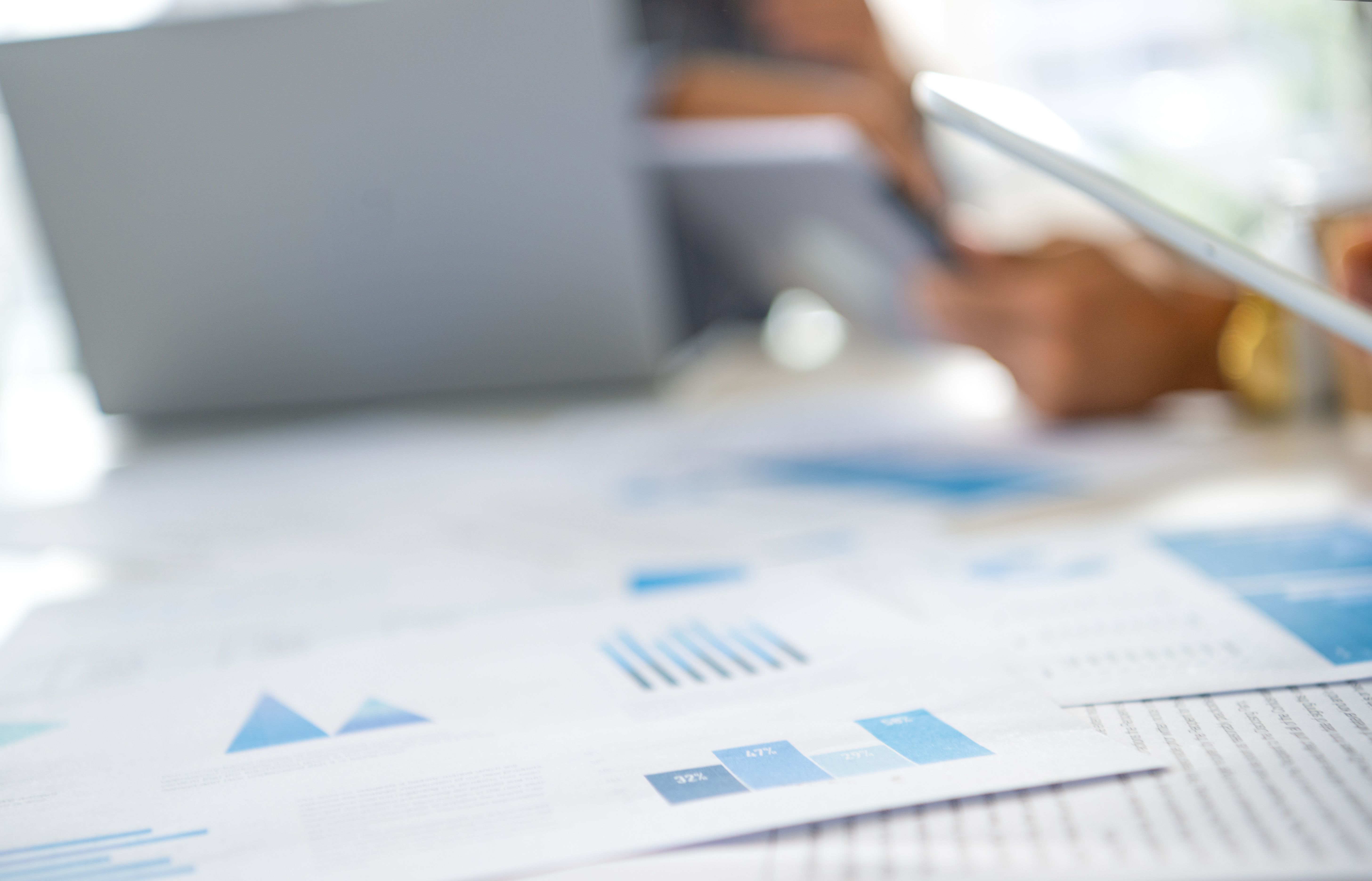 Defocussed image of Group of men working with Paperwork on a board room table at a business meeting or seminar.