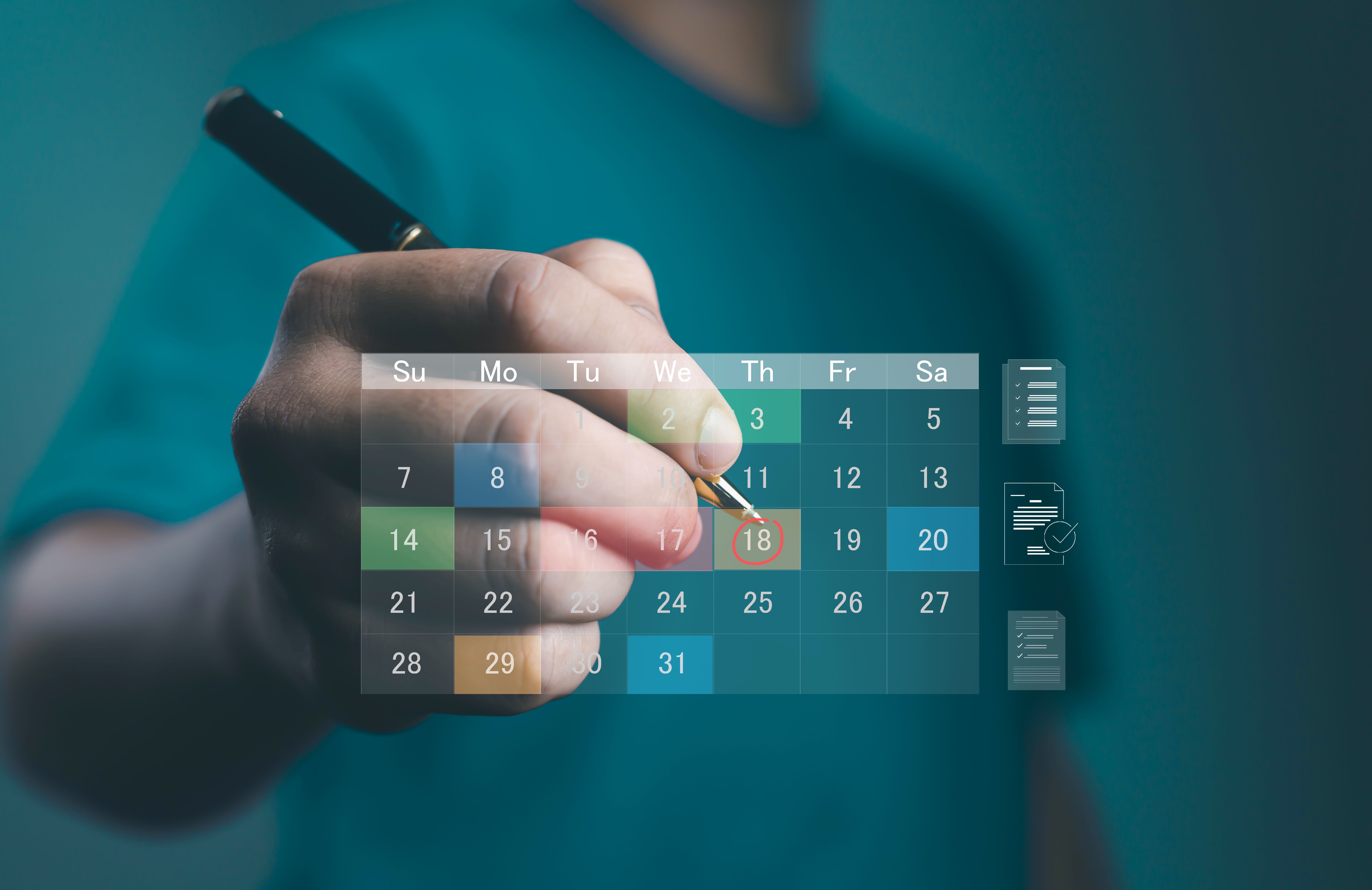 Businessman hand marking digital calendar with pen, concept of schedule planning, appointment reminder, event organization, time management, deadline tracking, and business productivity timeline