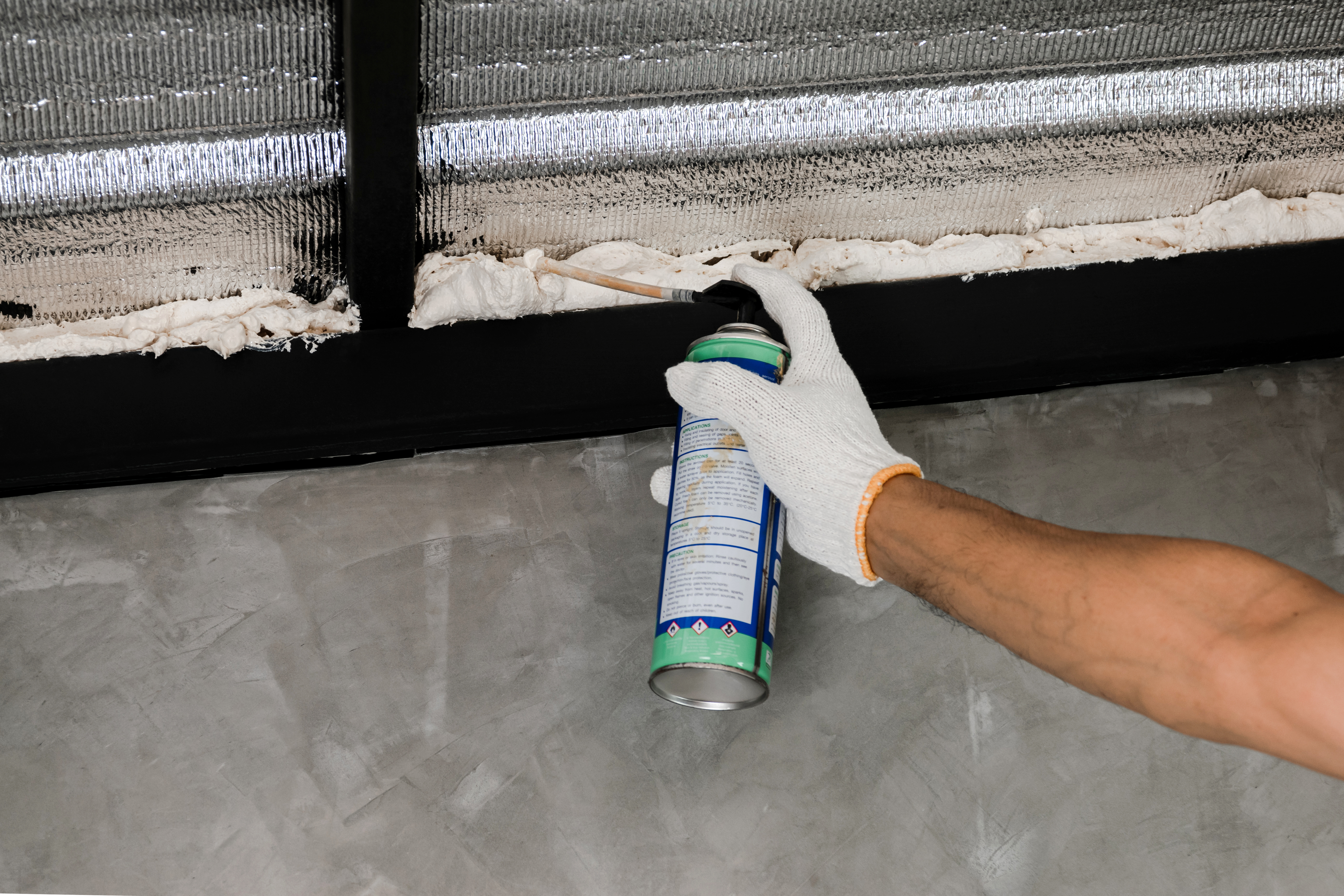 Human hand are caulking roof leaks with canned caulk foam. Human hand are caulking roof leaks with canned caulk foam.