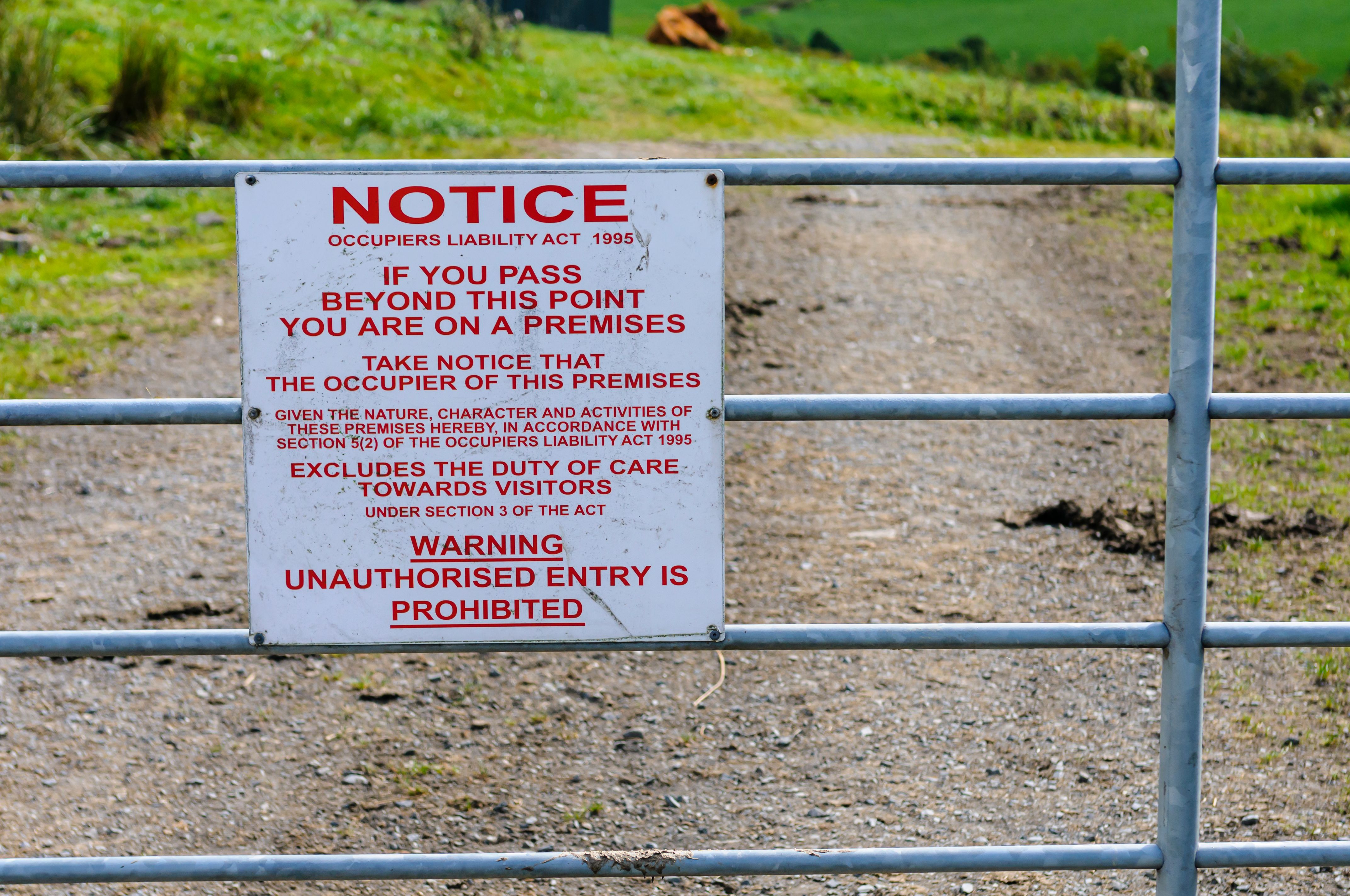 Occupiers Liability Act 1995 (Ireland) notice sign on the gate of a farm warning that unauthorised entry is prohibited.