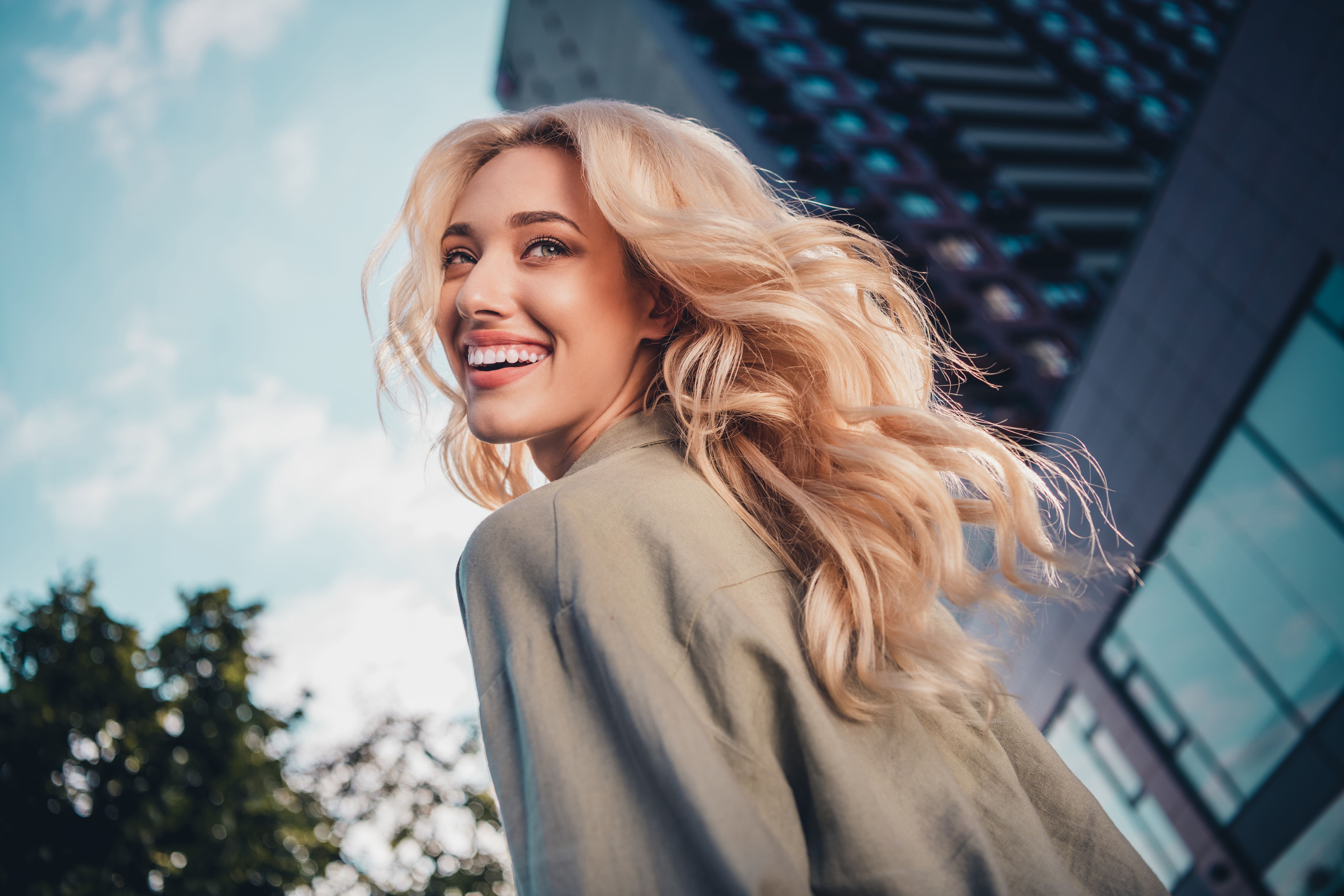 Profile side view portrait of attractive cheerful wavy haired girl spending spare time strolling in town outdoors Profile side view portrait of attractive cheerful wavy haired girl spending spare time strolling in town outdoors