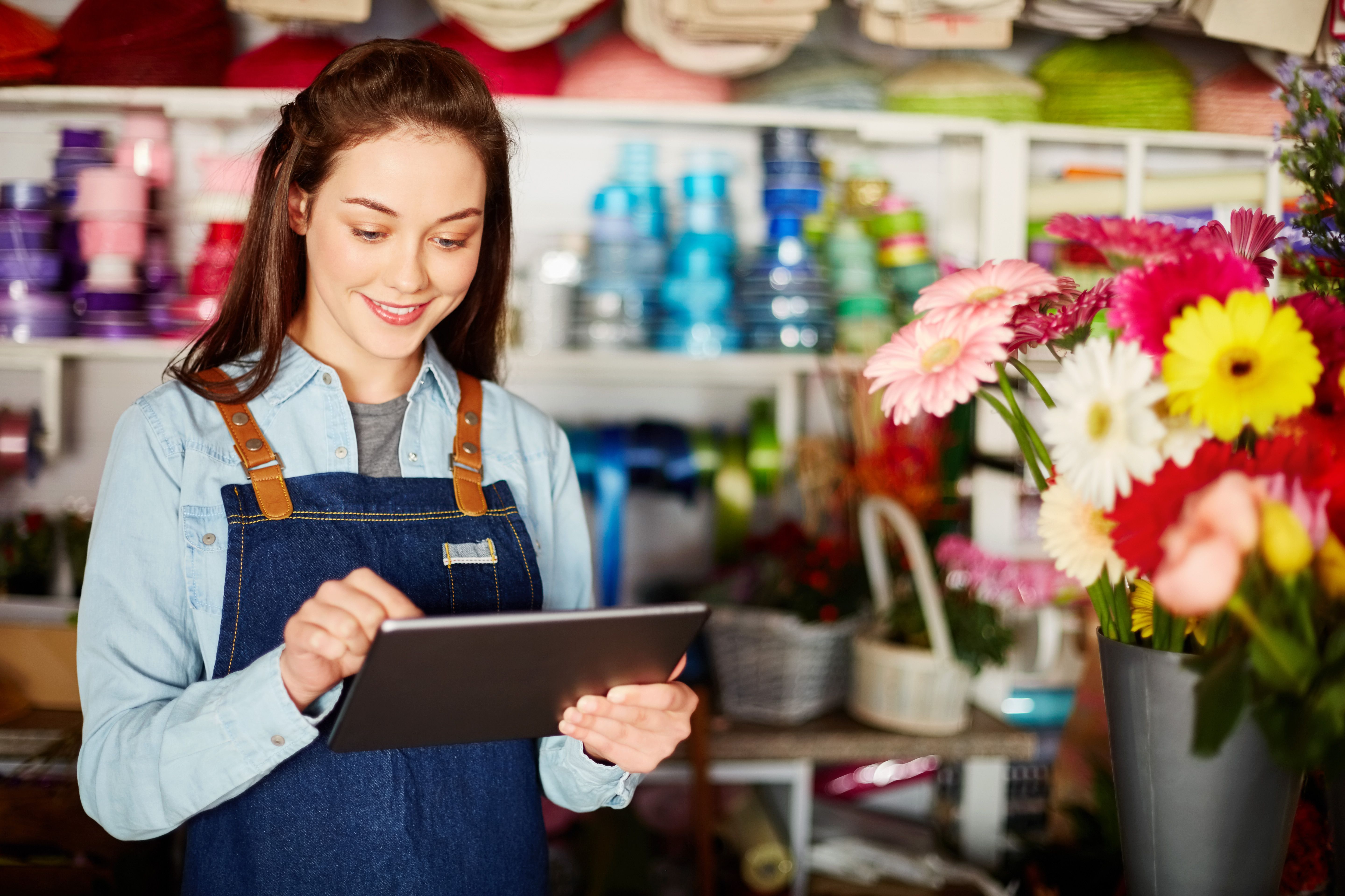 Female florist using tablet computer in flower shop