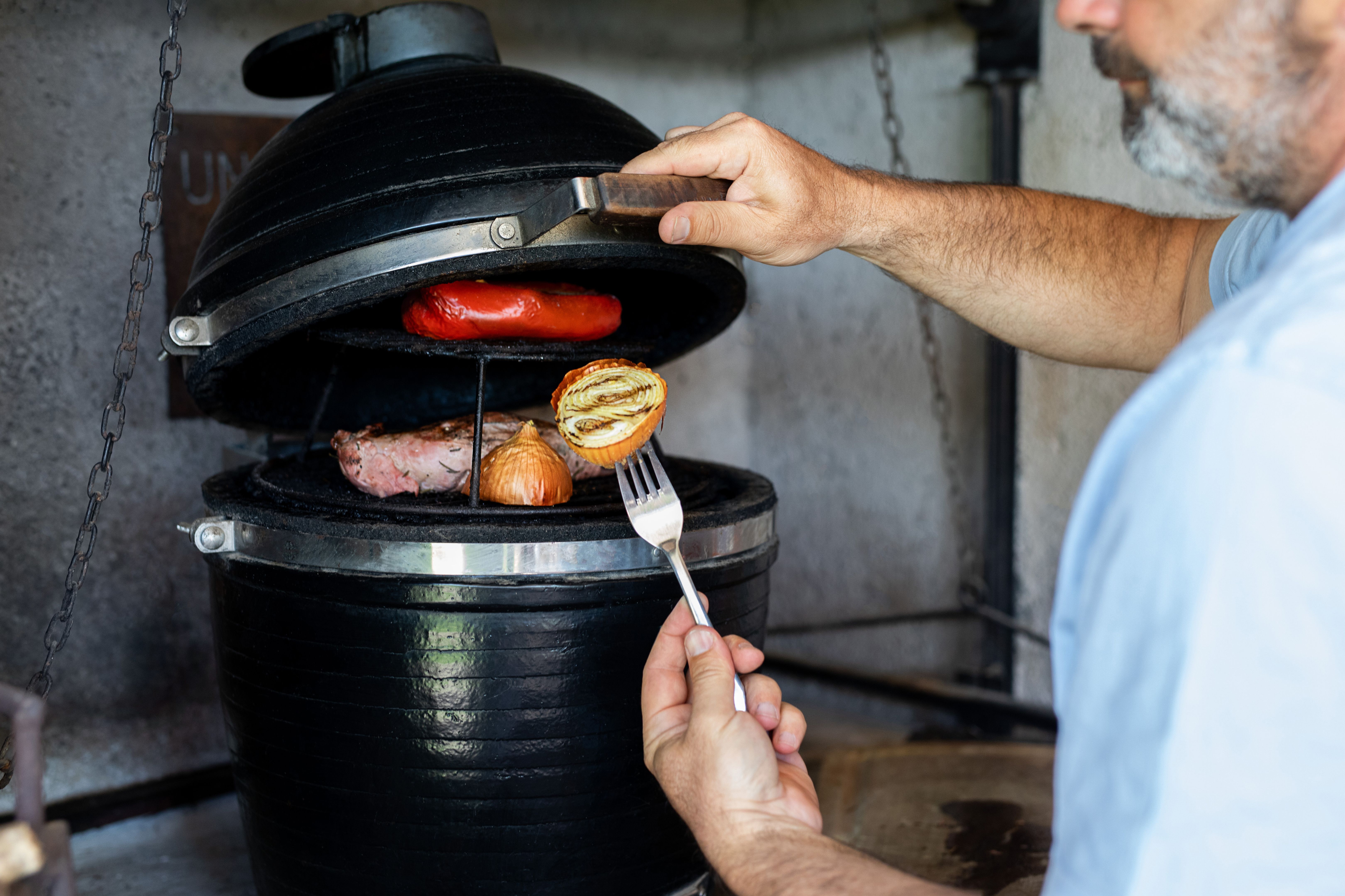 Argentine man preparing a barbecue on a smoker grill Argentine man preparing a barbecue on a smoker grill