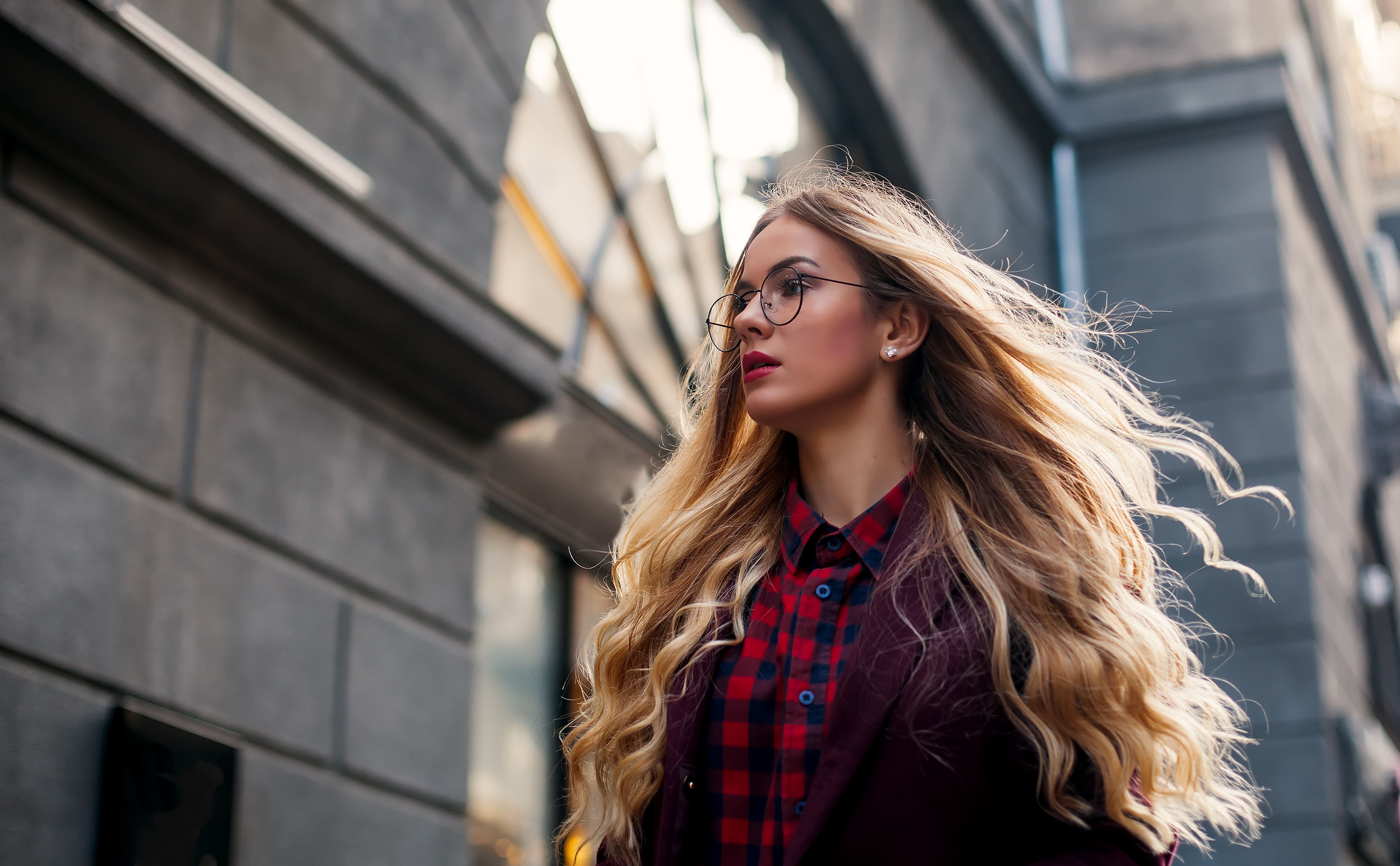 The concept of street fashion. Young beautiful model in the city. Beautiful blond woman wearing sunglasses. Hair fluttering in the wind. The concept of street fashion. Young beautiful model in the city. Beautiful blond woman wearing sunglasses. Hair fluttering in the wind.