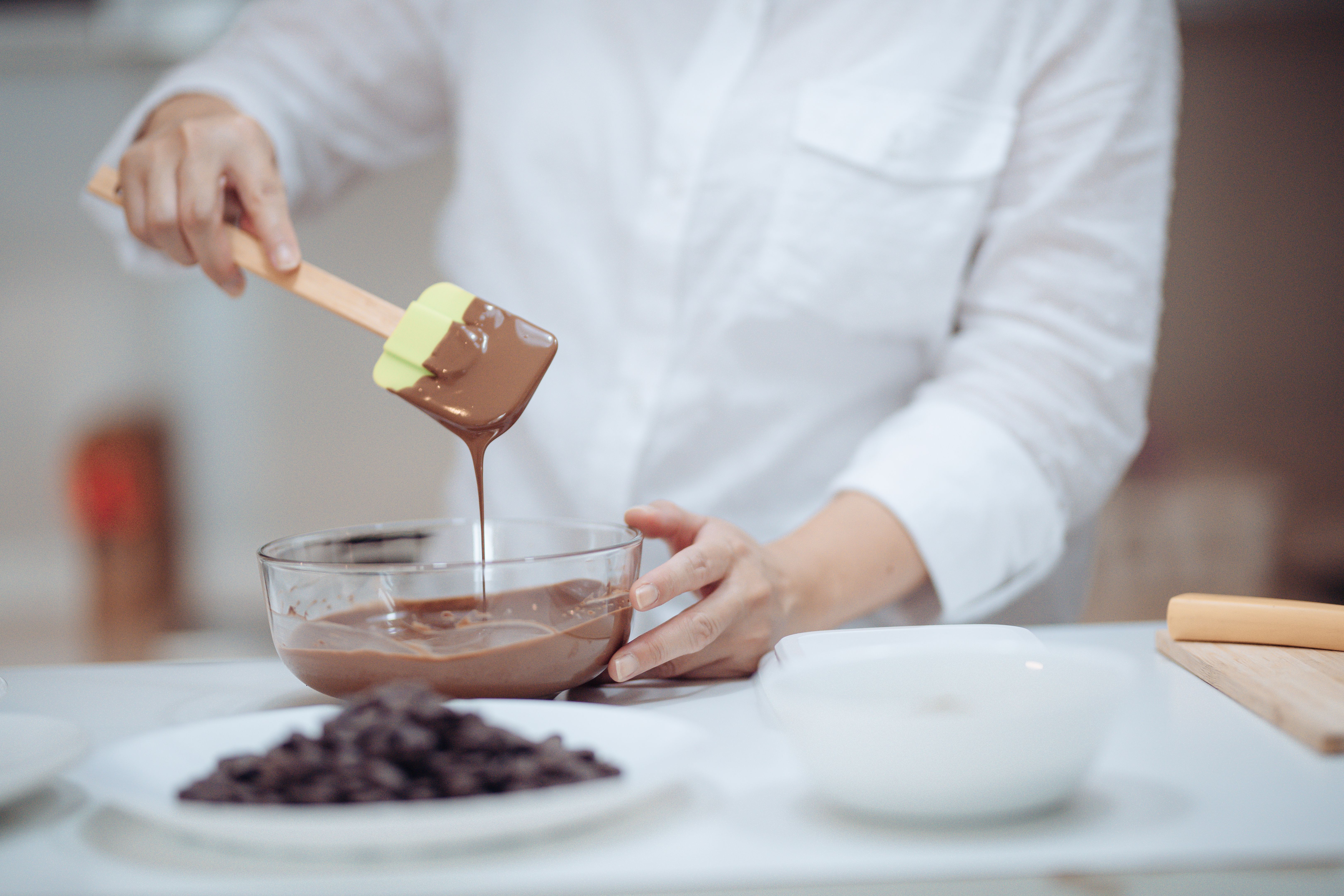 an asian chinese female desert chef preparing chocolate truffles at home mixing and scrapping chocolate an asian chinese female desert chef preparing chocolate truffles at home mixing and scrapping chocolate