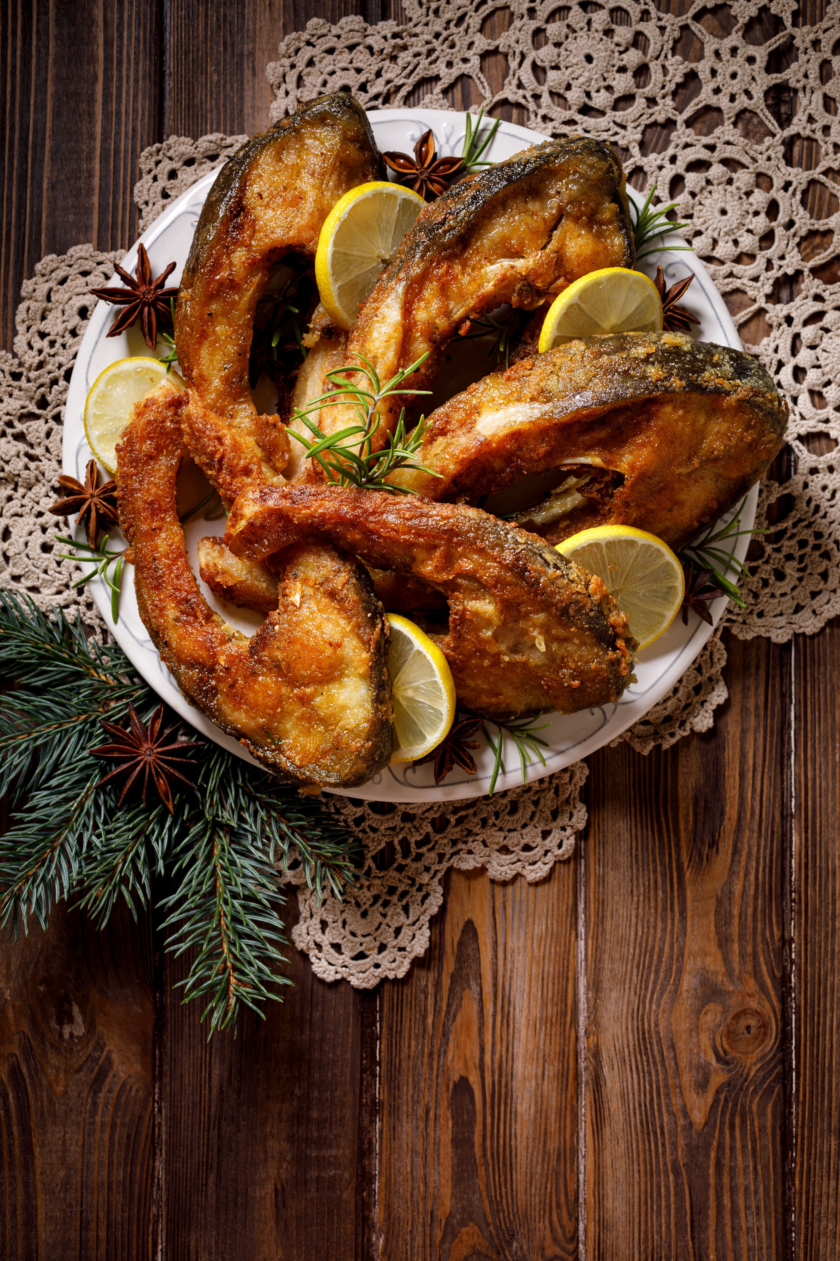 Christmas carp, Fried carp fish slices on a ceramic plate on the holiday table, top view. Traditional christmas eve dish.