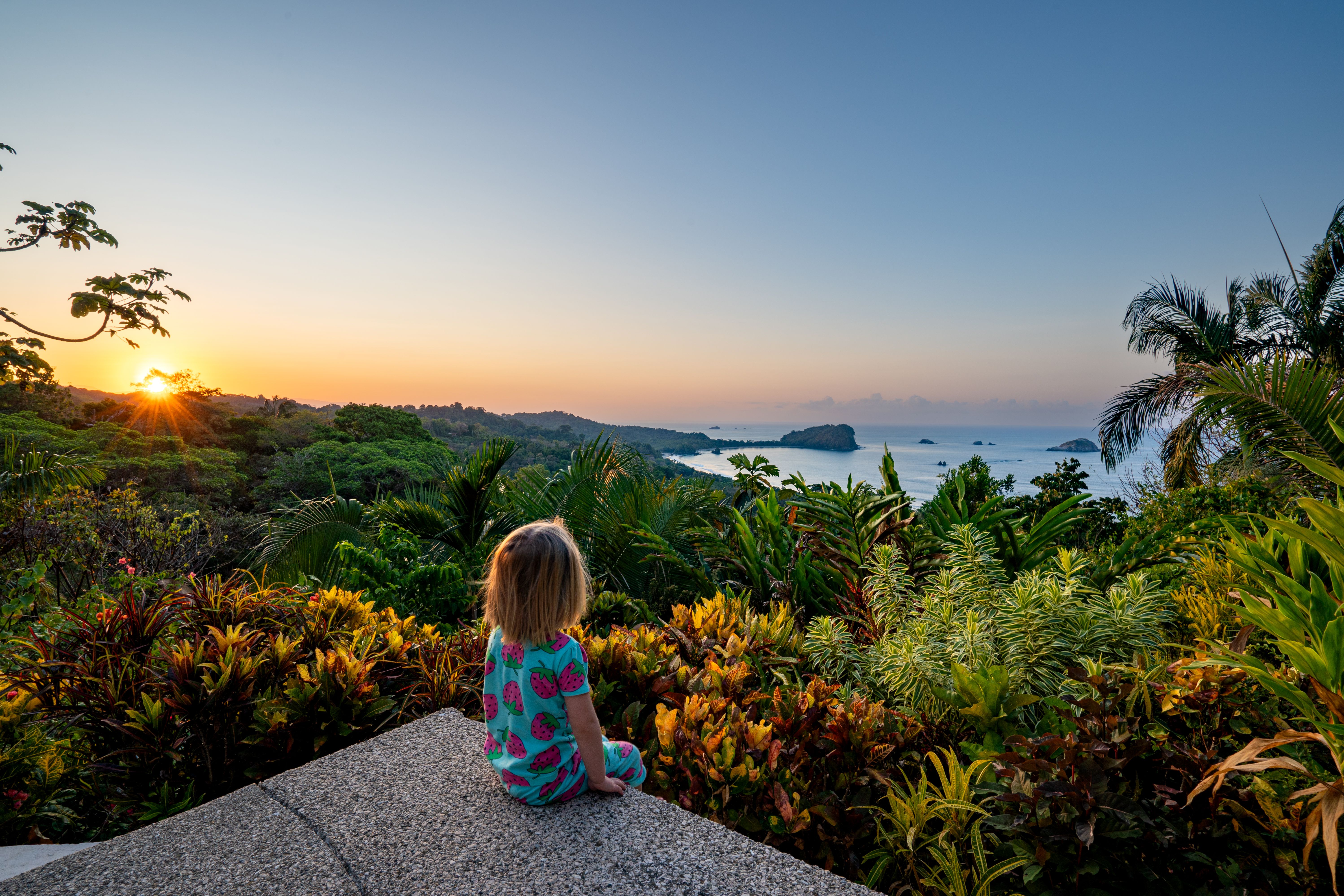 Toddler Girl Enjoying a Vibrant Sunrise over the Wild Untamed Coastal Beauty of Manuel Antonio National Park on the Pacific Coast of Costa Rica