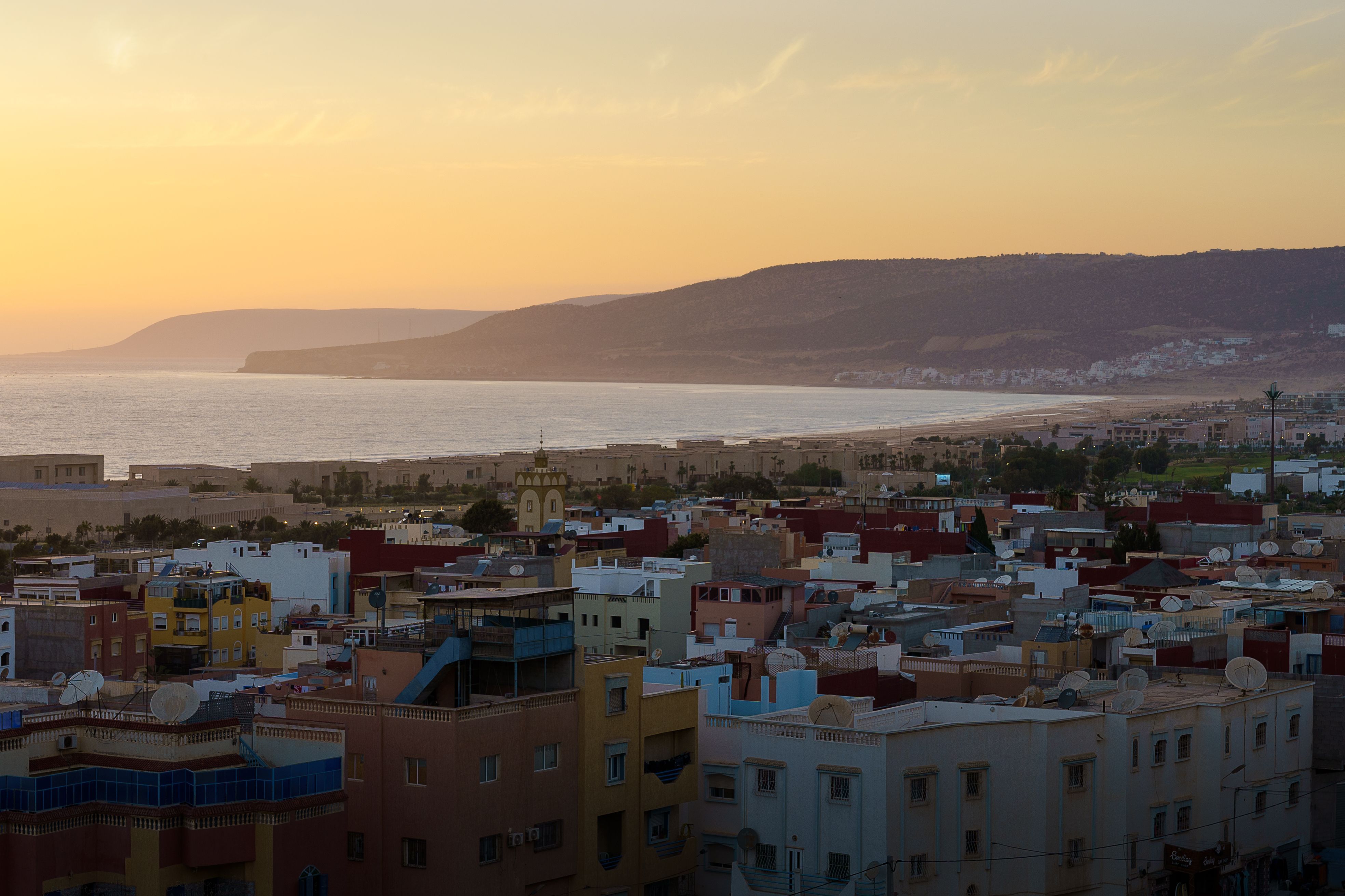 Aerial view of village Tamraght surrounded by buildings and water during sunset