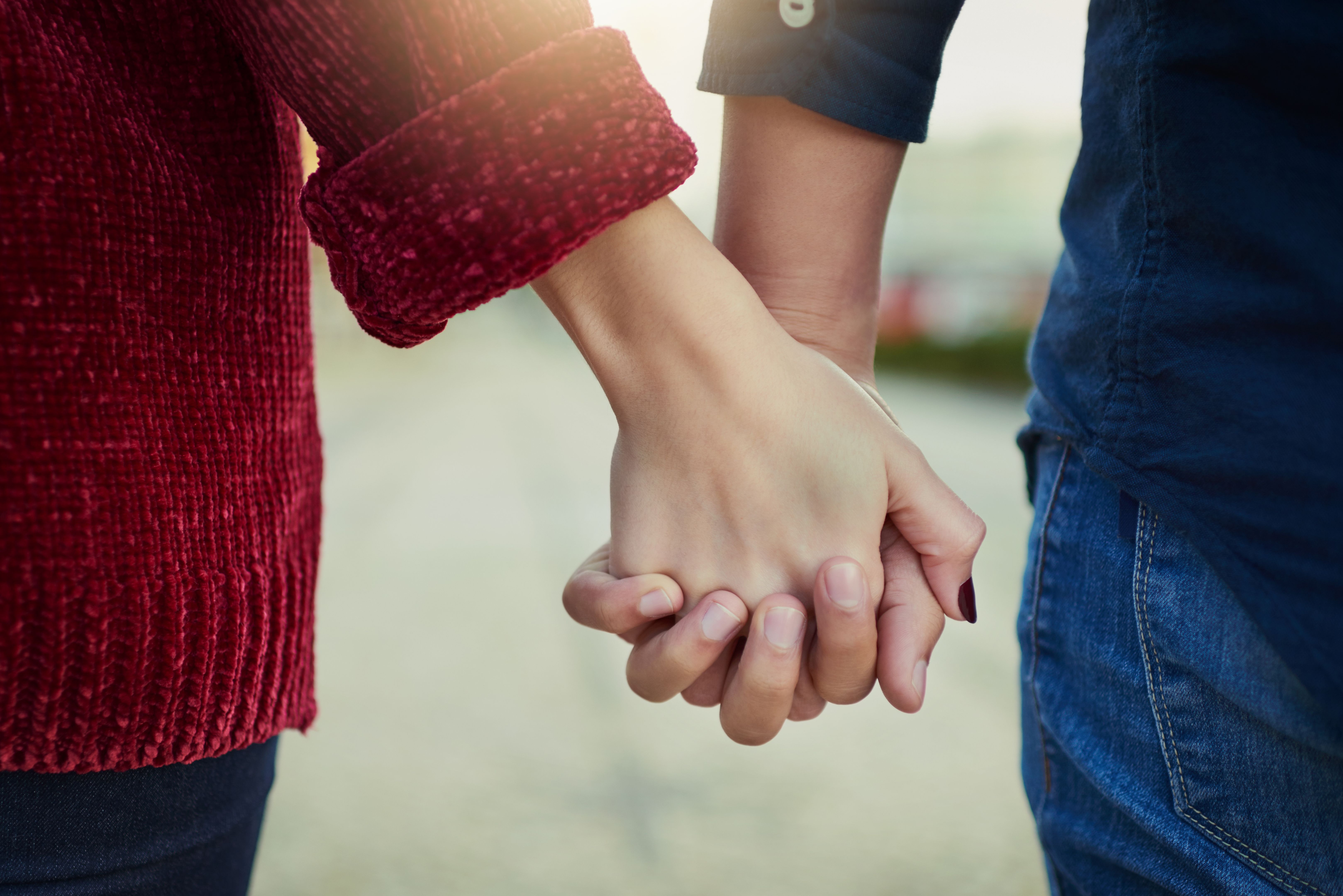 Couple holding hands and walking together, symbolizing moving forward in recovery and rebuilding connection in a marriage touched by addiction.