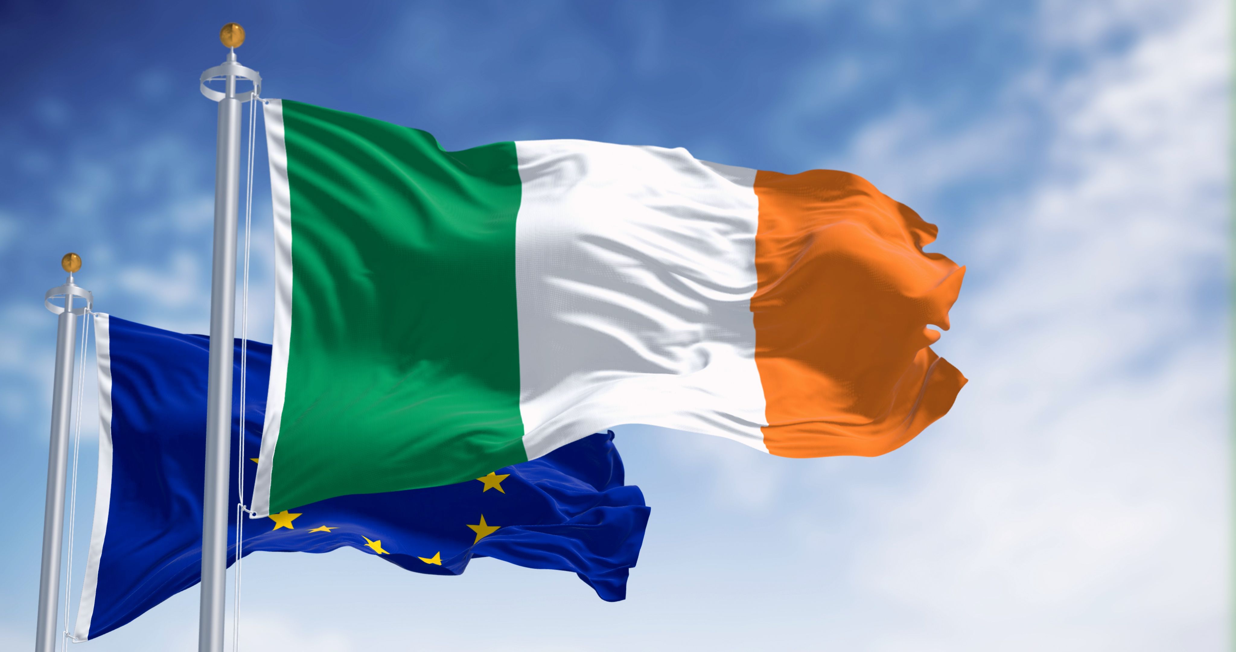 The flags of Ireland and the European Union fluttering together on a clear day The flags of Ireland and the European Union fluttering together on a clear day