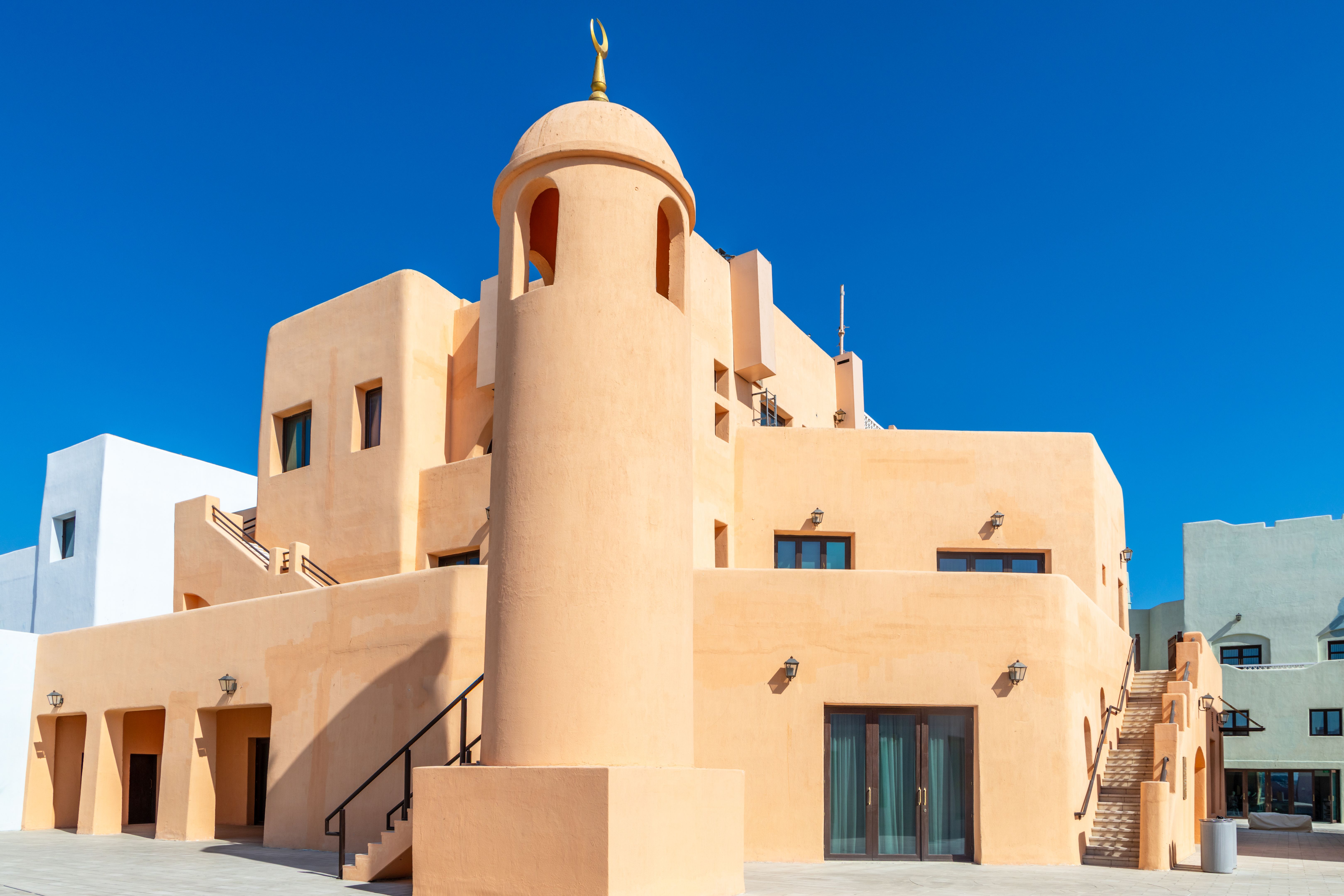 Colorful Mina village district street with modern traditional arab buildings and minaret, Doha, Qatar