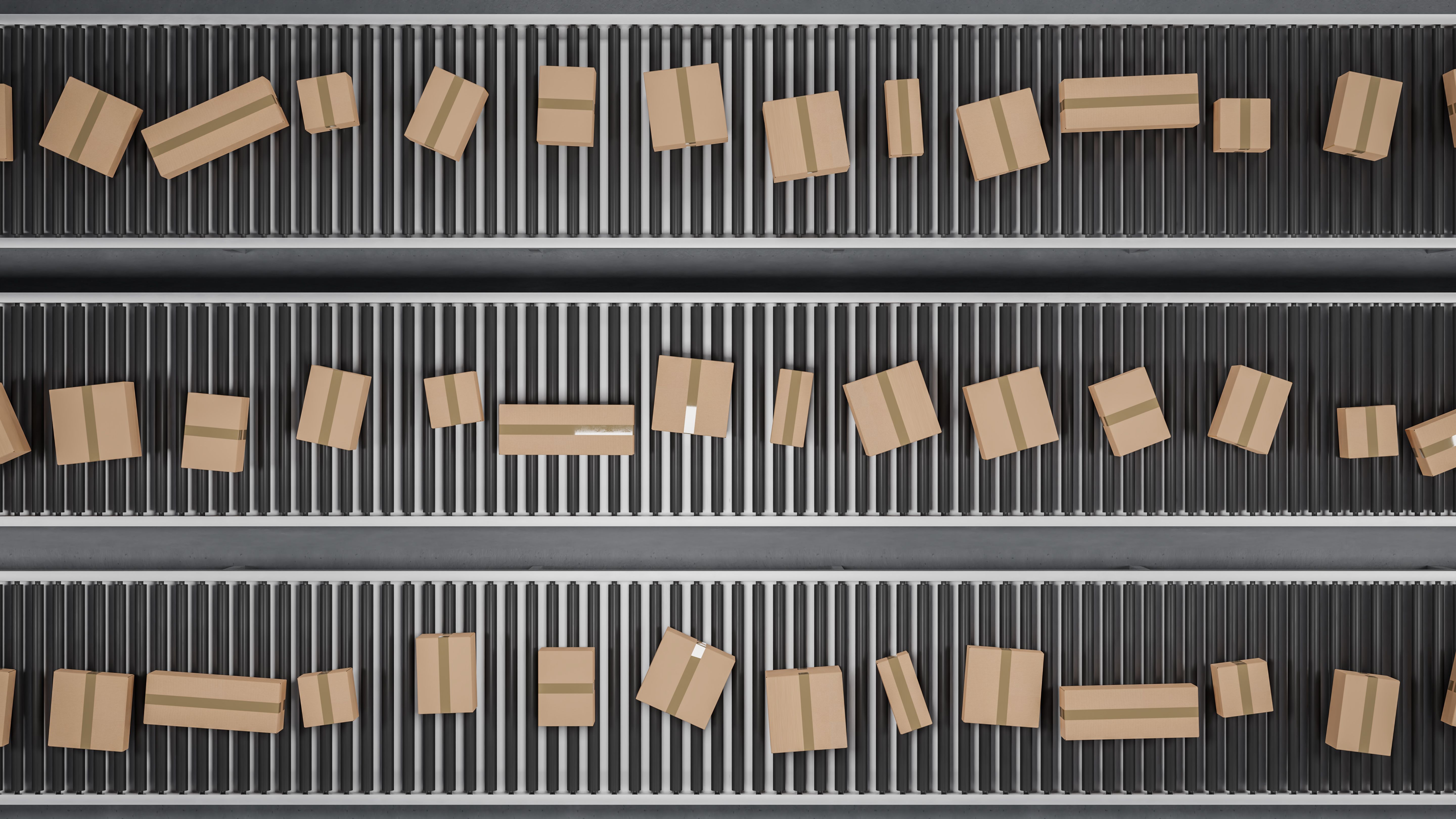 A large group of differently sized neutral cardboard boxes on a conveyor belt. Consumerism or mail order concept. Top down view
