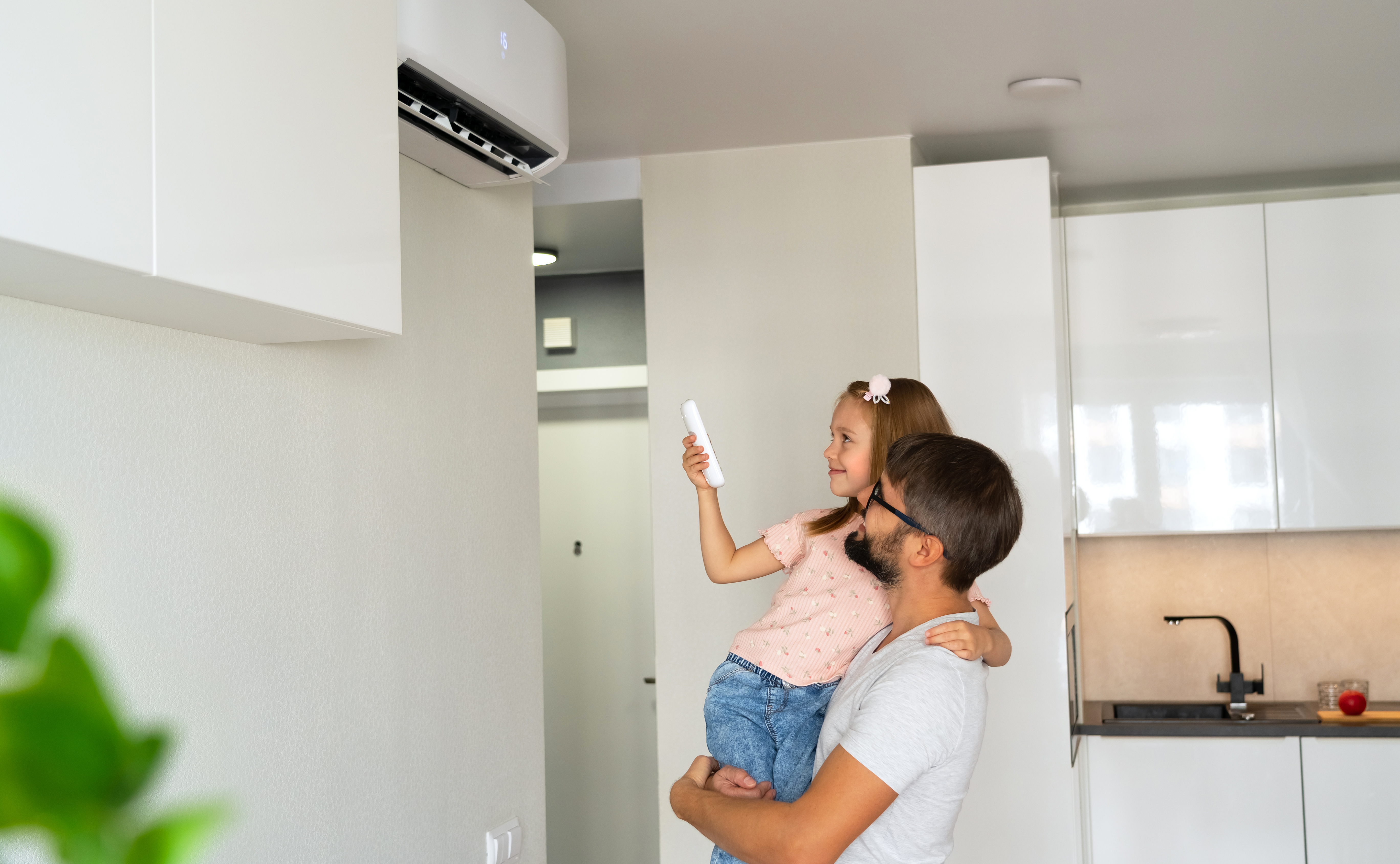 Family, father and child turn on air conditioner using remote control