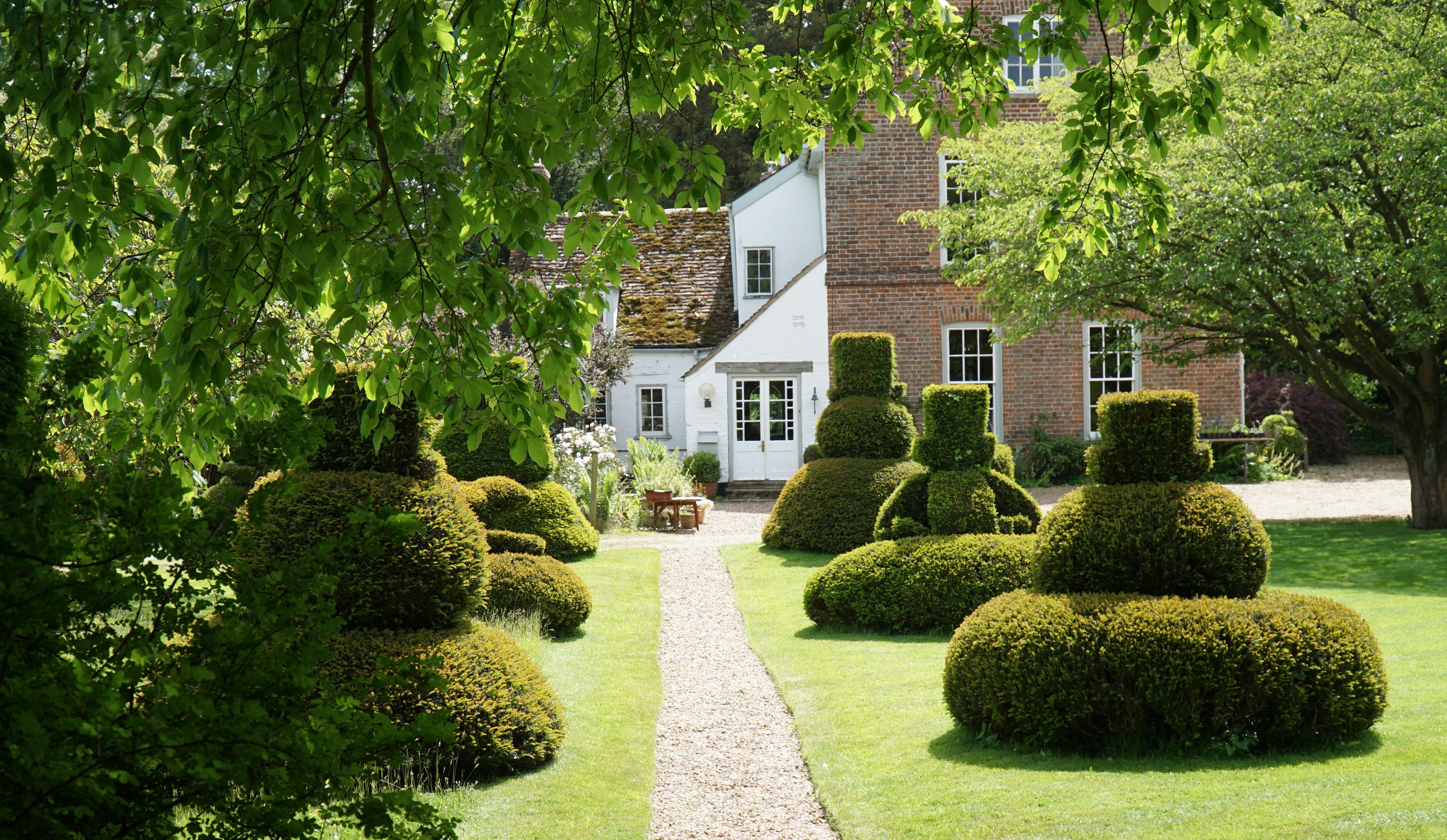 The Manor House at Hemmingford Grey with its impressive topiary. The Manor House at Hemmingford Grey with its impressive topiary.