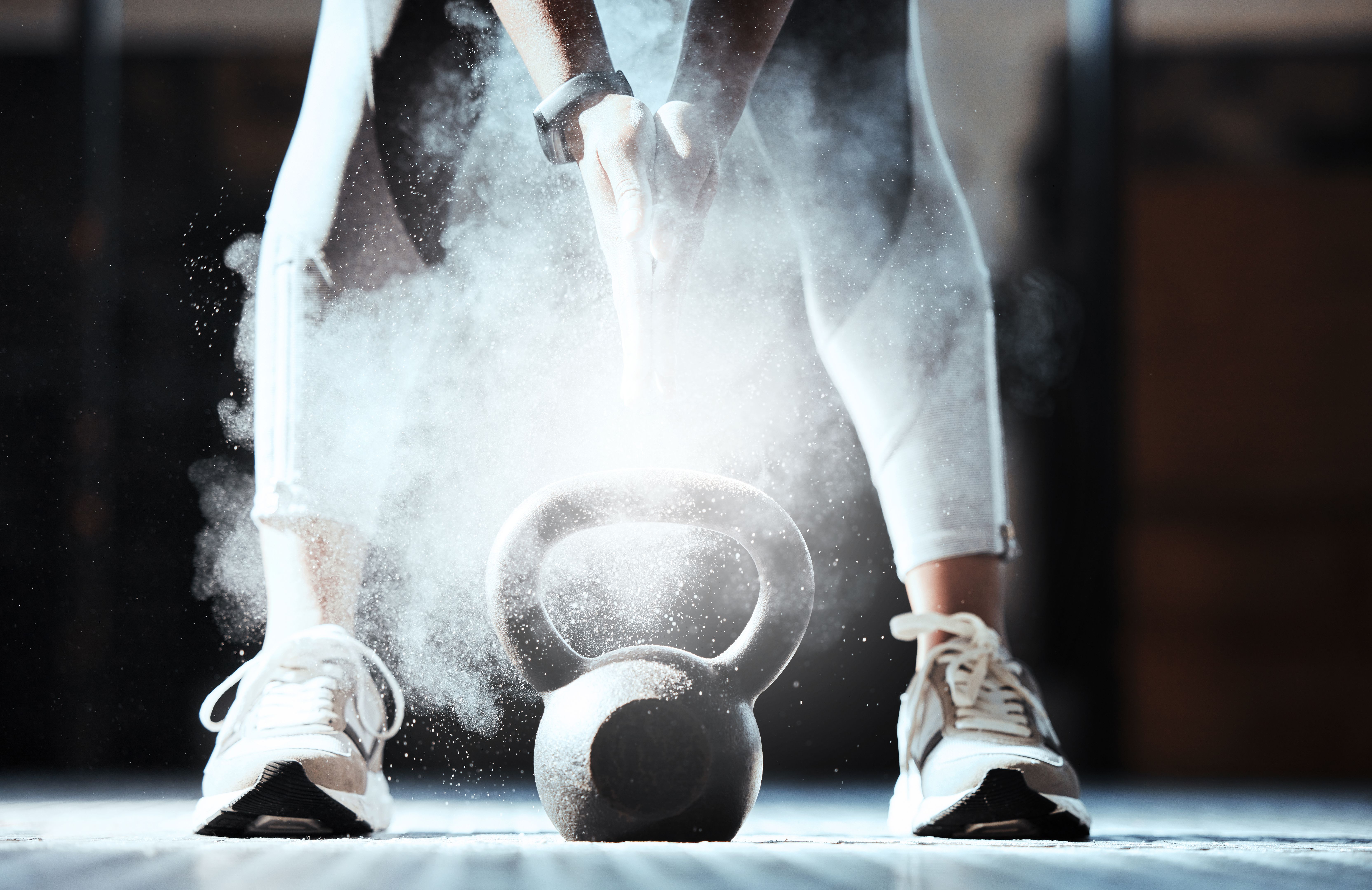Cropped shot of an unrecognizable woman lifting a kettlebell at the gym
