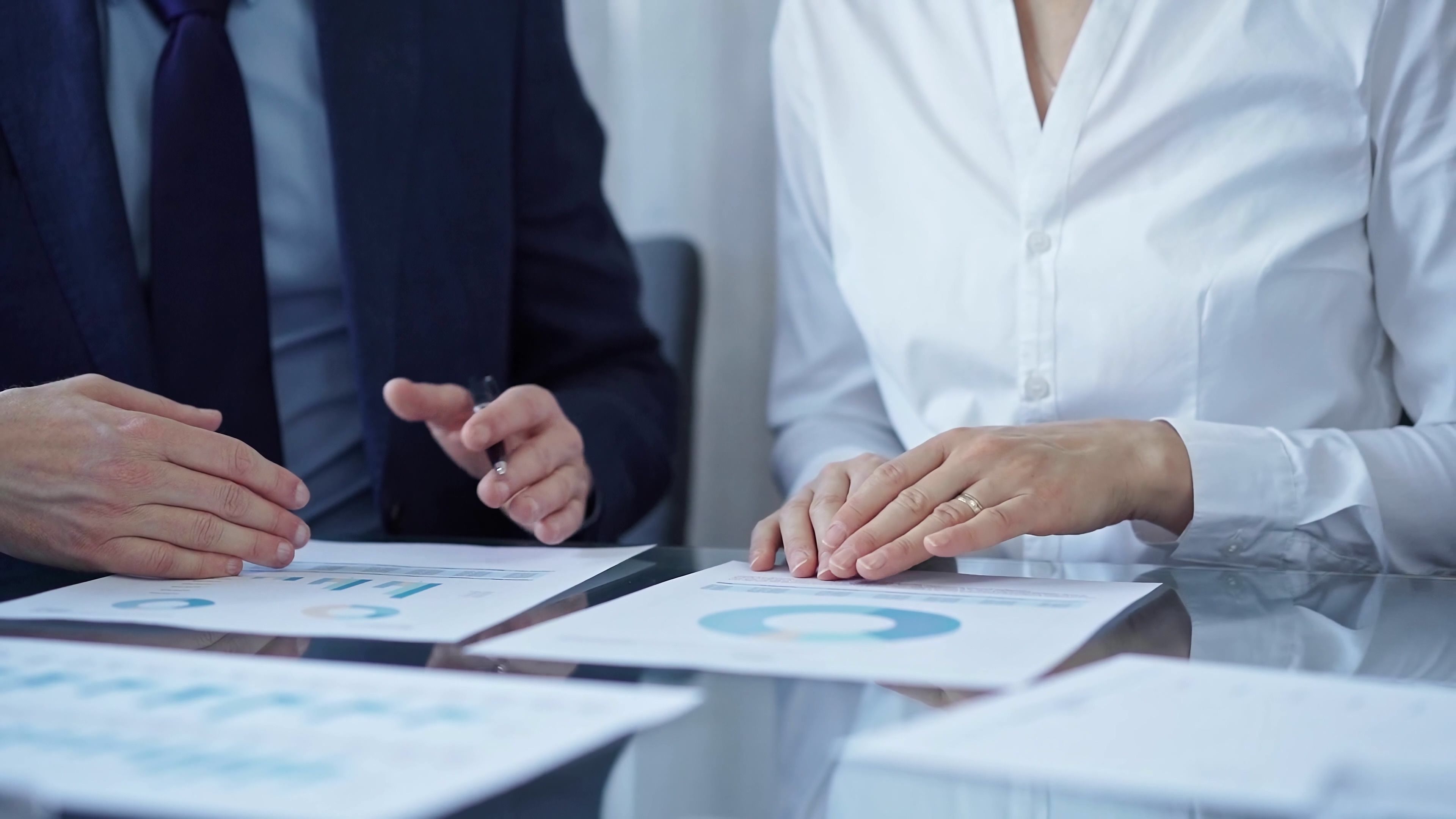 Business people wearing suits are reviewing a financial results and discussing the terms of the agreement. Teamwork and planning