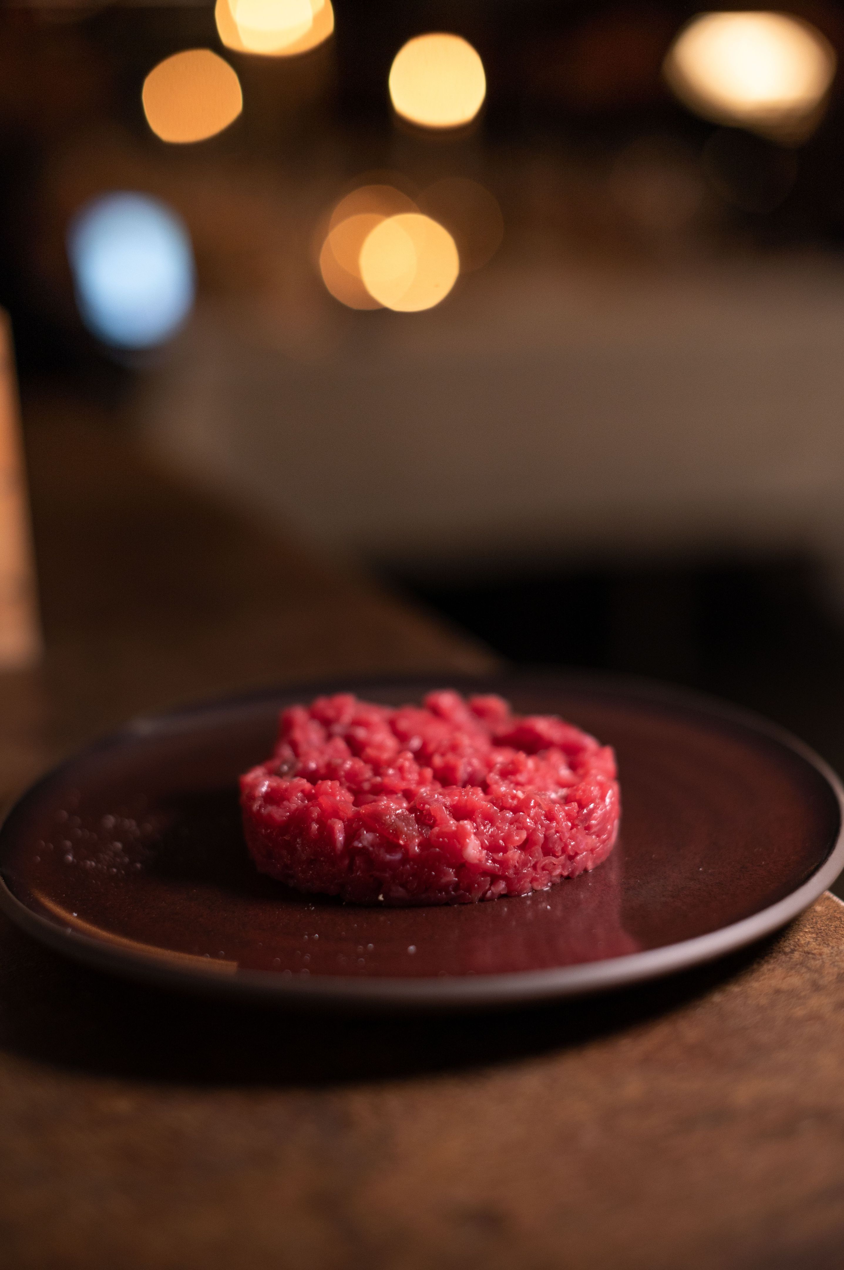 Selective focus shot of a carne cruda on a plate on a dark background