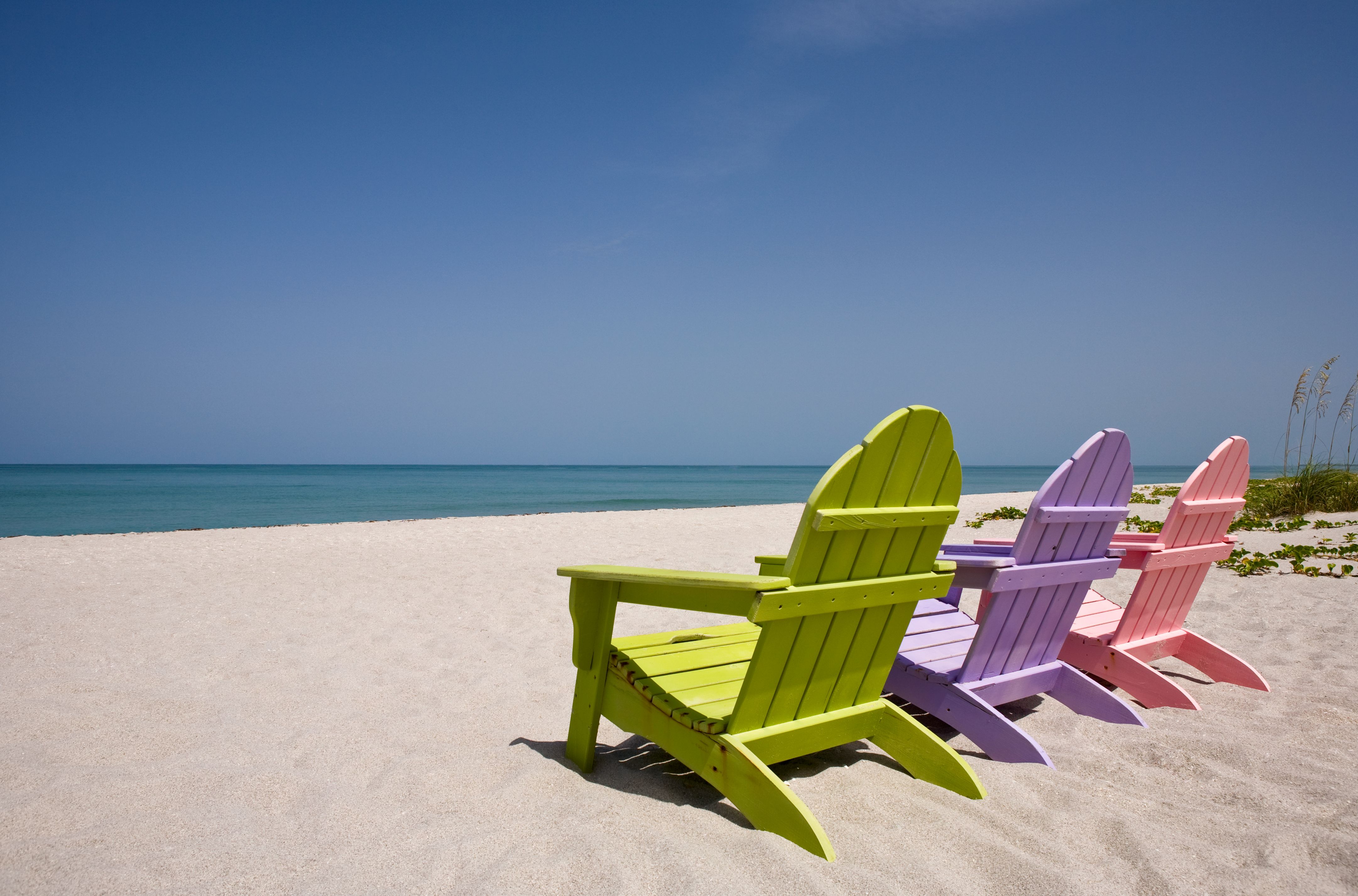 Three wooden chairs on beautiful deserted sandy beach Three wooden chairs on beautiful deserted sandy beach