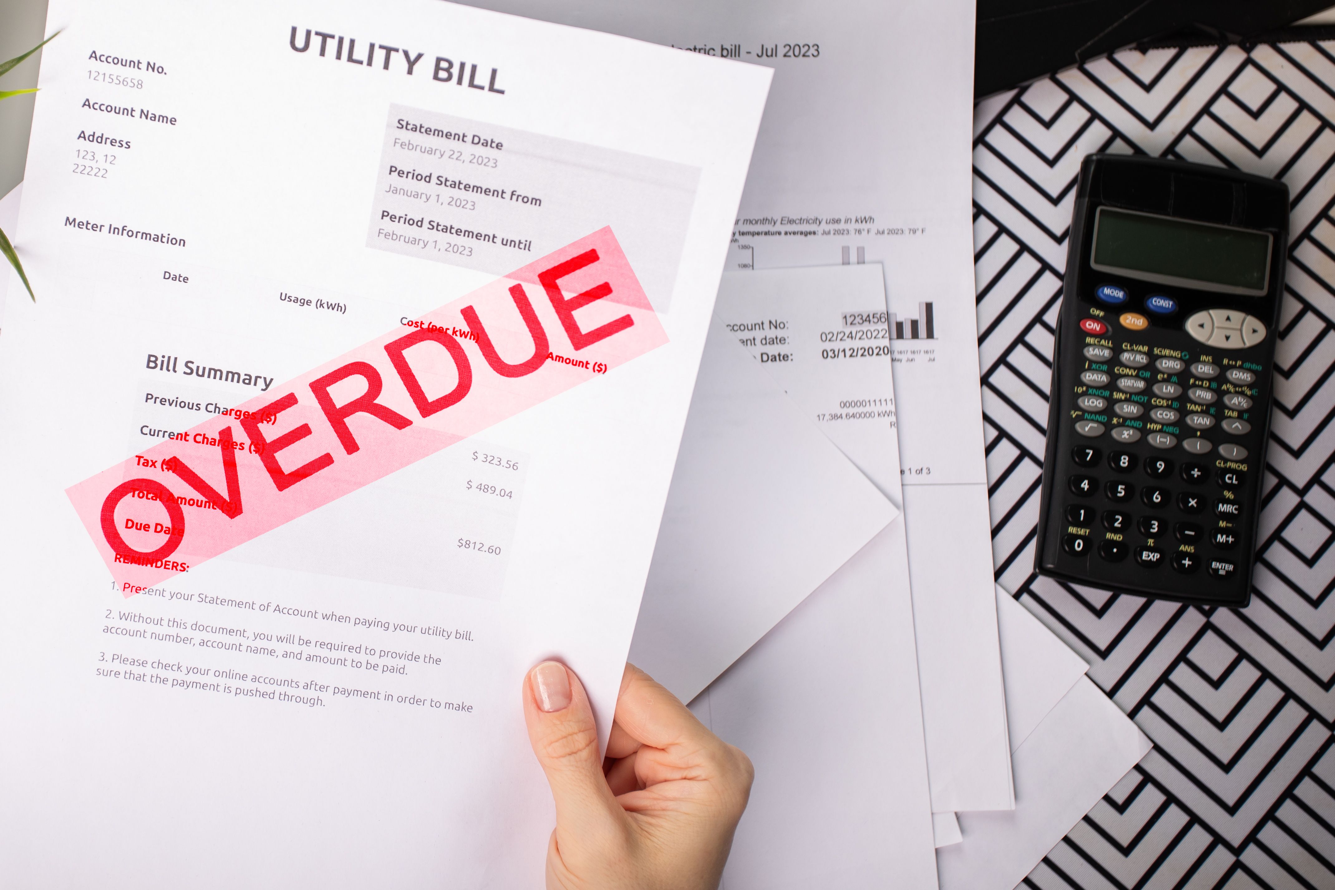 Overdue Utility Bill Notice in hand, home power and heat expense, financial document and customer payment status