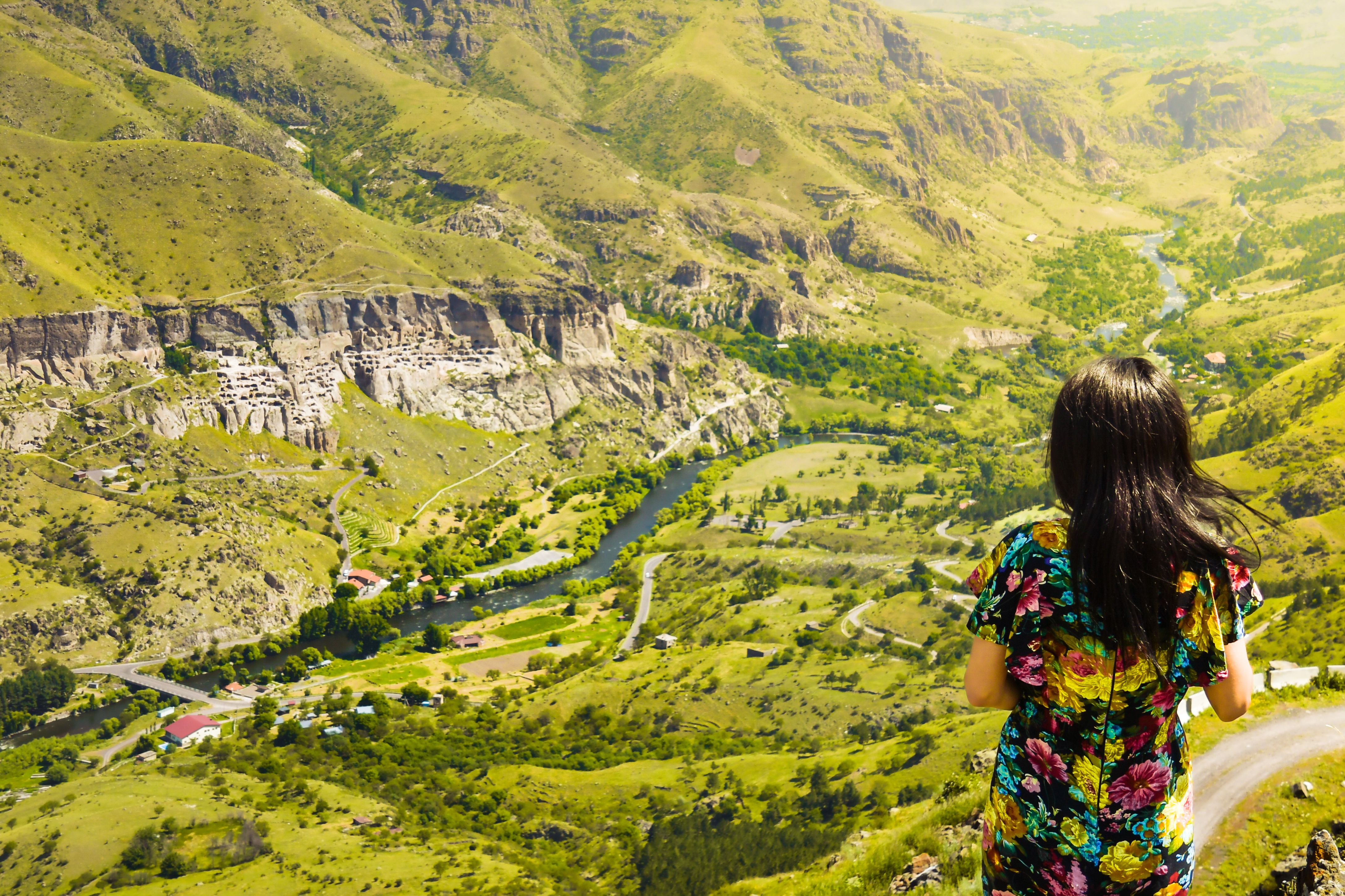 Female caucasian tourist enjoy stunning panoramic landscape view of Vardzia cave city and valley