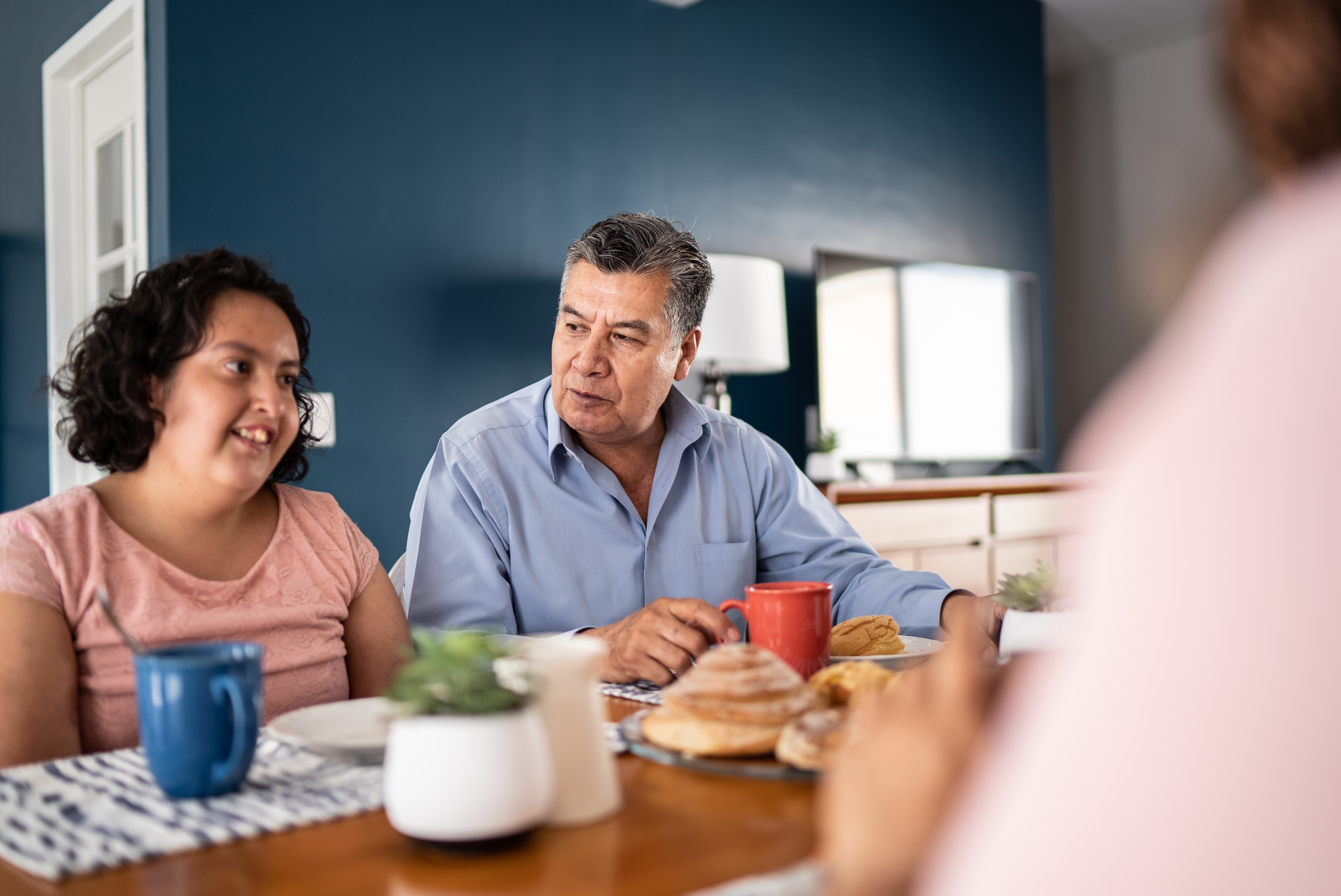 Father and psychomotor Intellectual disability daughter having breakfast at home