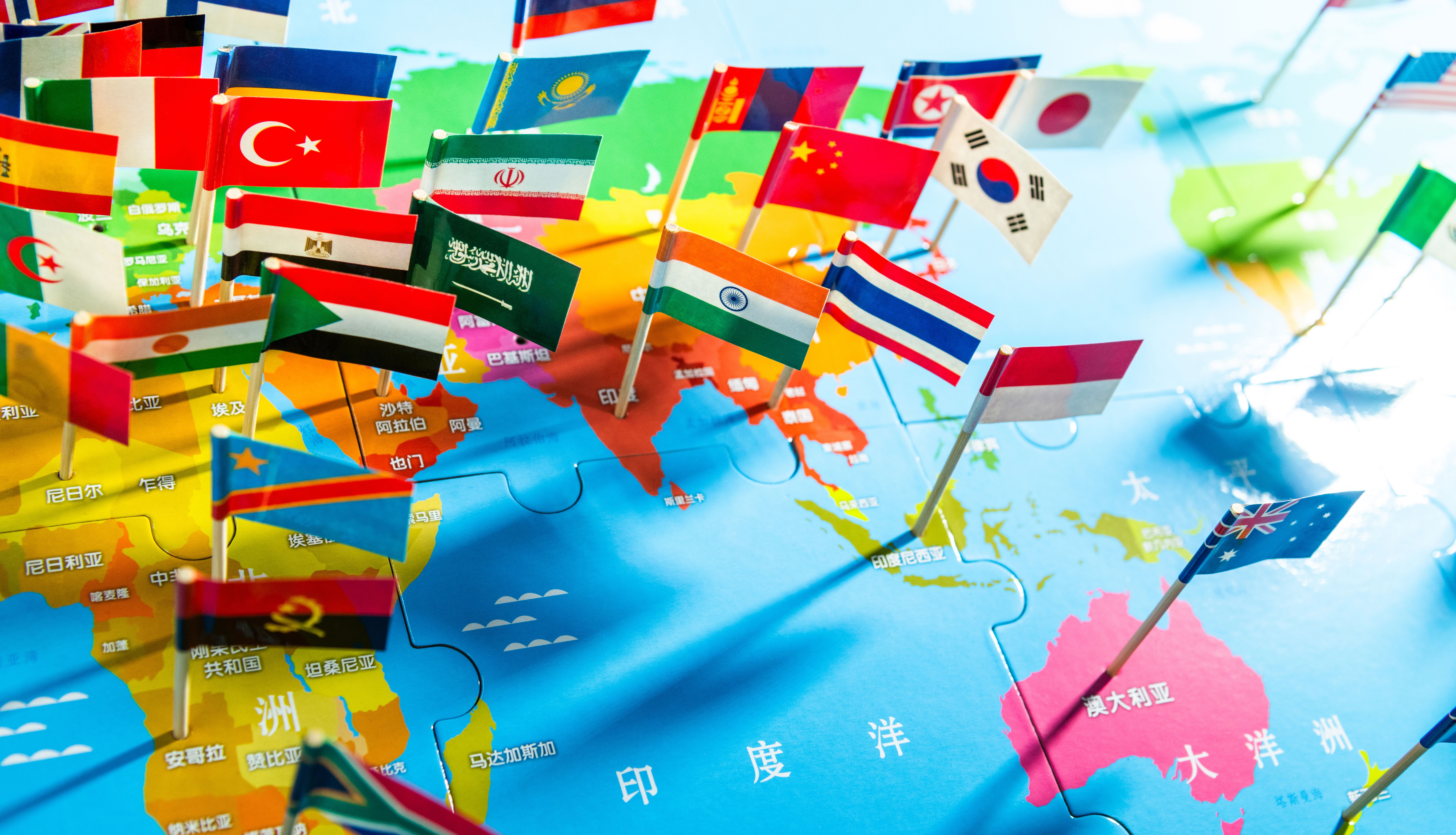 National flags of the different countries on the world map. The place names written on the map use Chinese characters