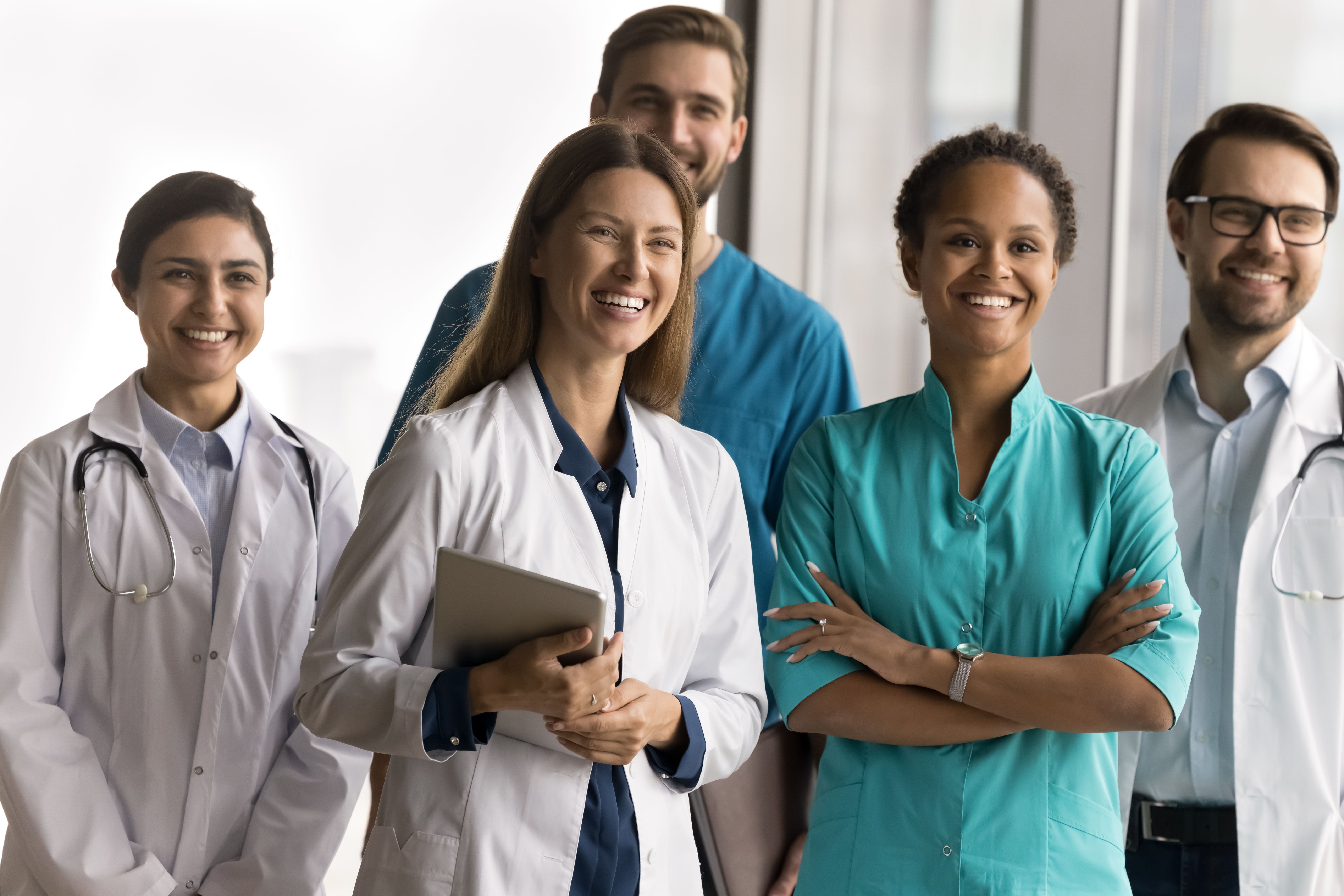Multiethnic millennial healthcare team posing together in clinic