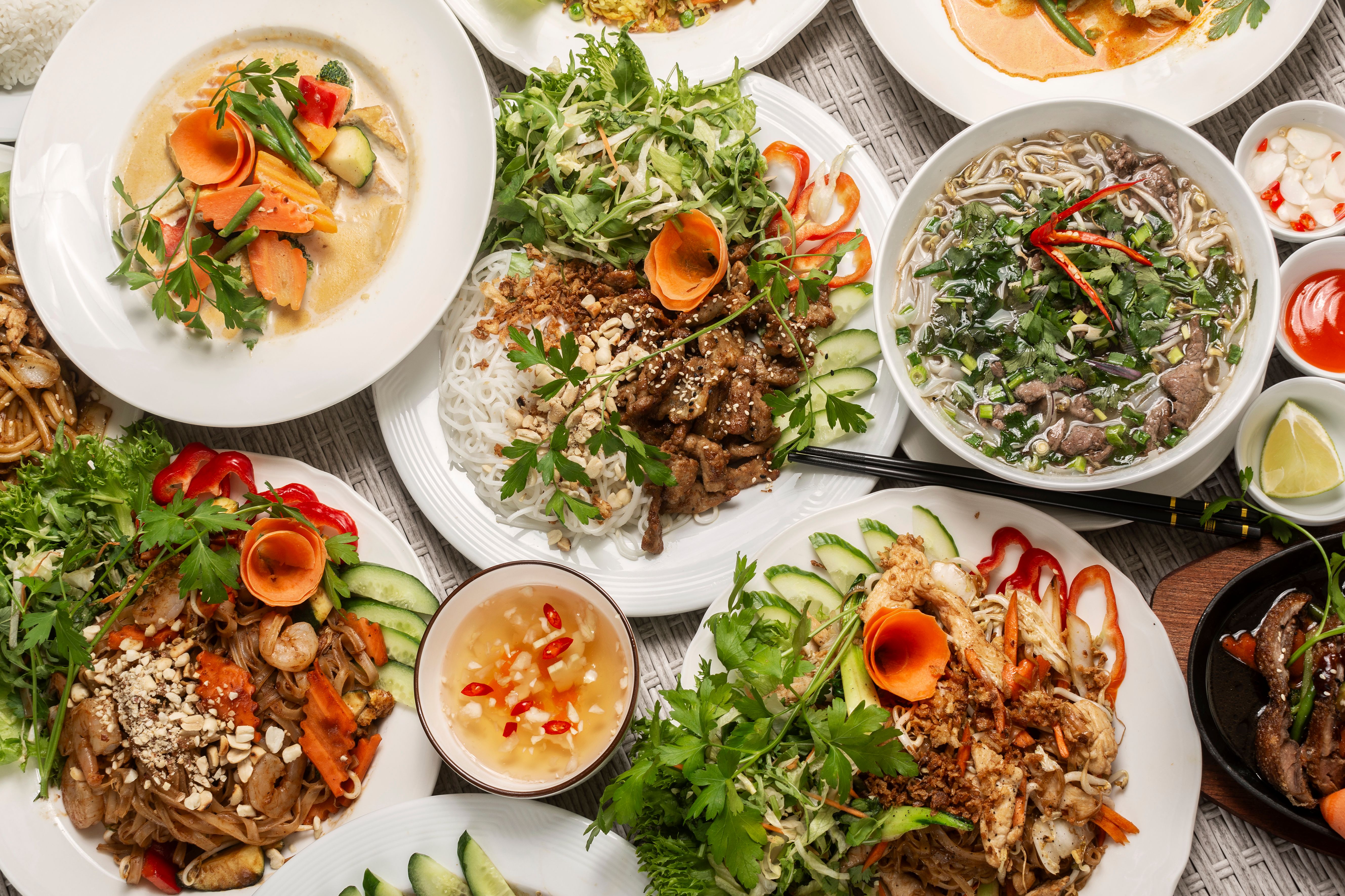 assortment of mixed traditional vietnamese food dishes on buffet table